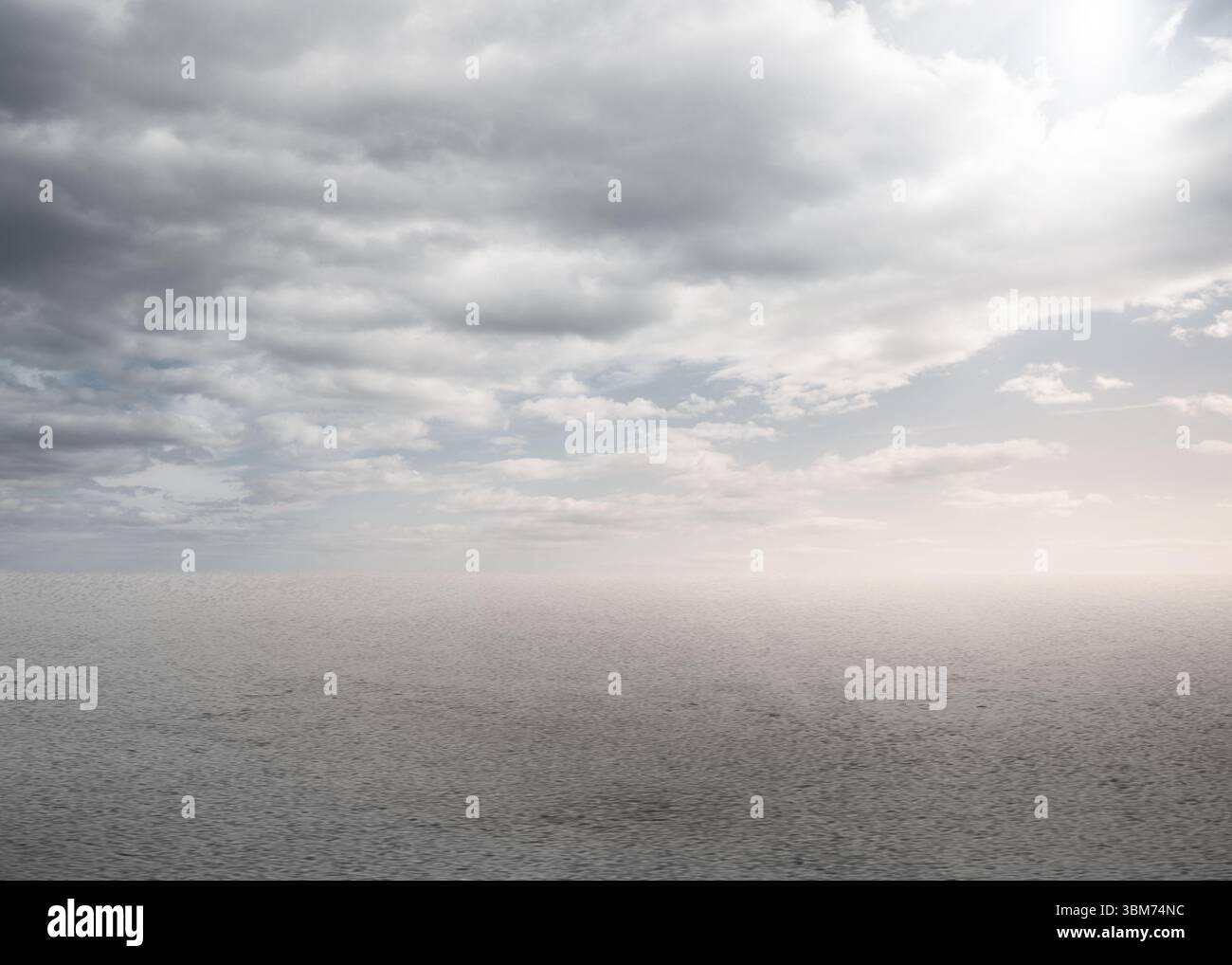 La superficie del mare aperto riflette lievi increspature in un design piatto con cielo coperto e bagliore caldo Foto Stock