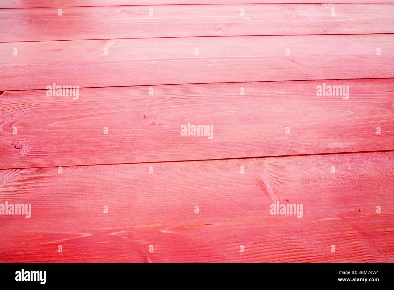 Design piatto con tavole di legno verniciate di rosso che coprono la larghezza, evidenziando la grana e le cuciture Foto Stock