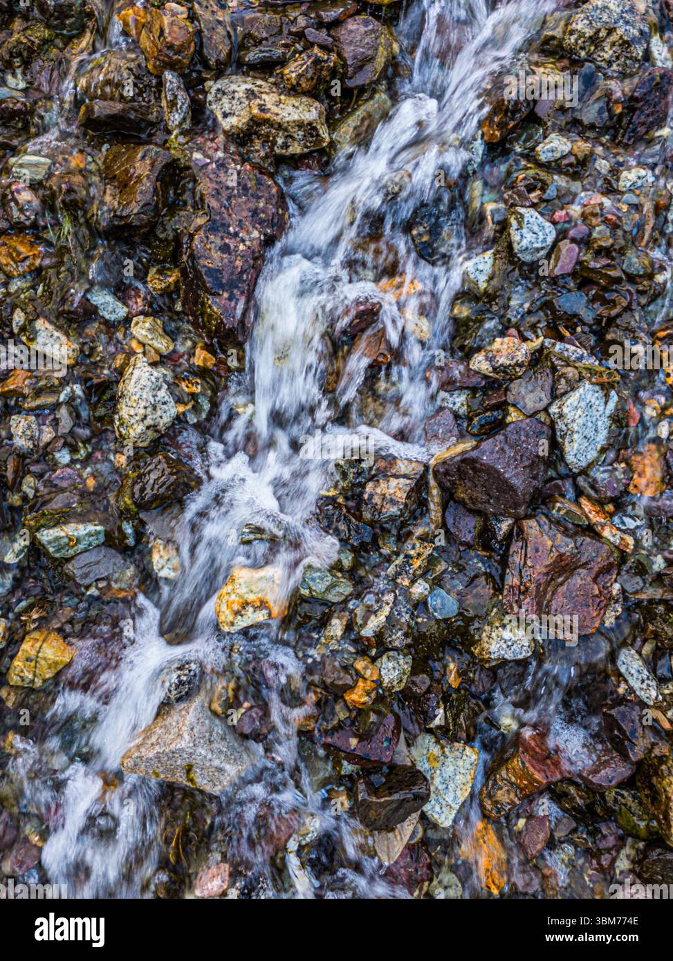 Sereno ruscello che scorre su rocce colorate in natura Foto Stock