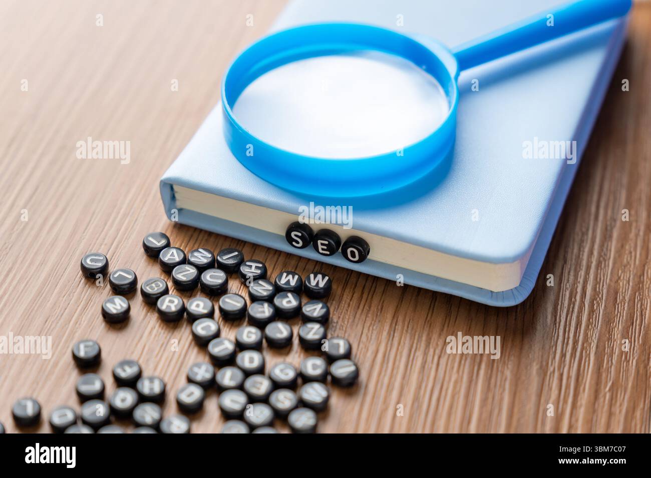 Perline alfabetiche che scrivono "SEO" con perline più sparse su un tavolo di legno. Marketing digitale, analisi dei dati e concetto di scoperta delle informazioni. Foto Stock