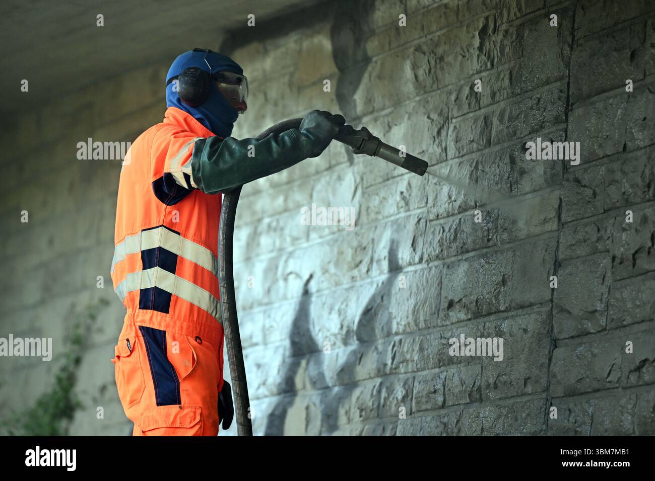 Essen, Germania. 25 giugno 2025. David Brown rimuove i graffiti con una sabbiatrice a bassa pressione. I graffiti vengono rimossi con una sabbiatrice a Löwental nell'Essen-Werden. Crediti: Federico Gambarini/dpa/Alamy Live News Foto Stock