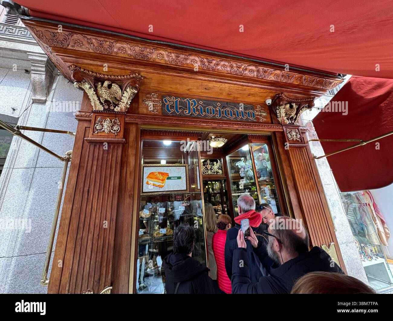 Persone in fila davanti a Pasteleria El Riojano, calle Mayor, Madrid, Spagna Foto Stock