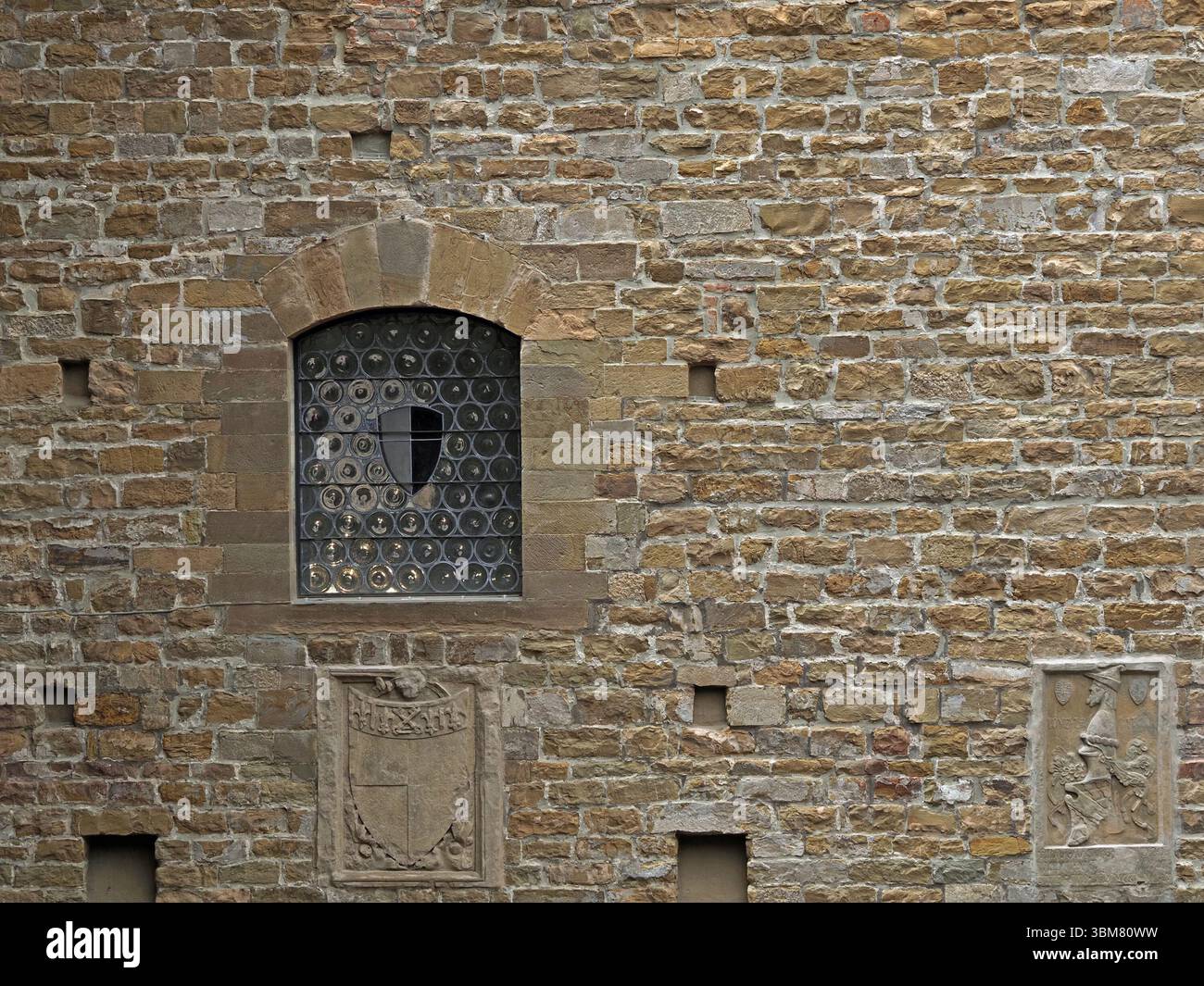 Muro del cortile interno del Bargello a Firenze, Italia con stemmi in gesso, incavi e vetrate ad arco Foto Stock