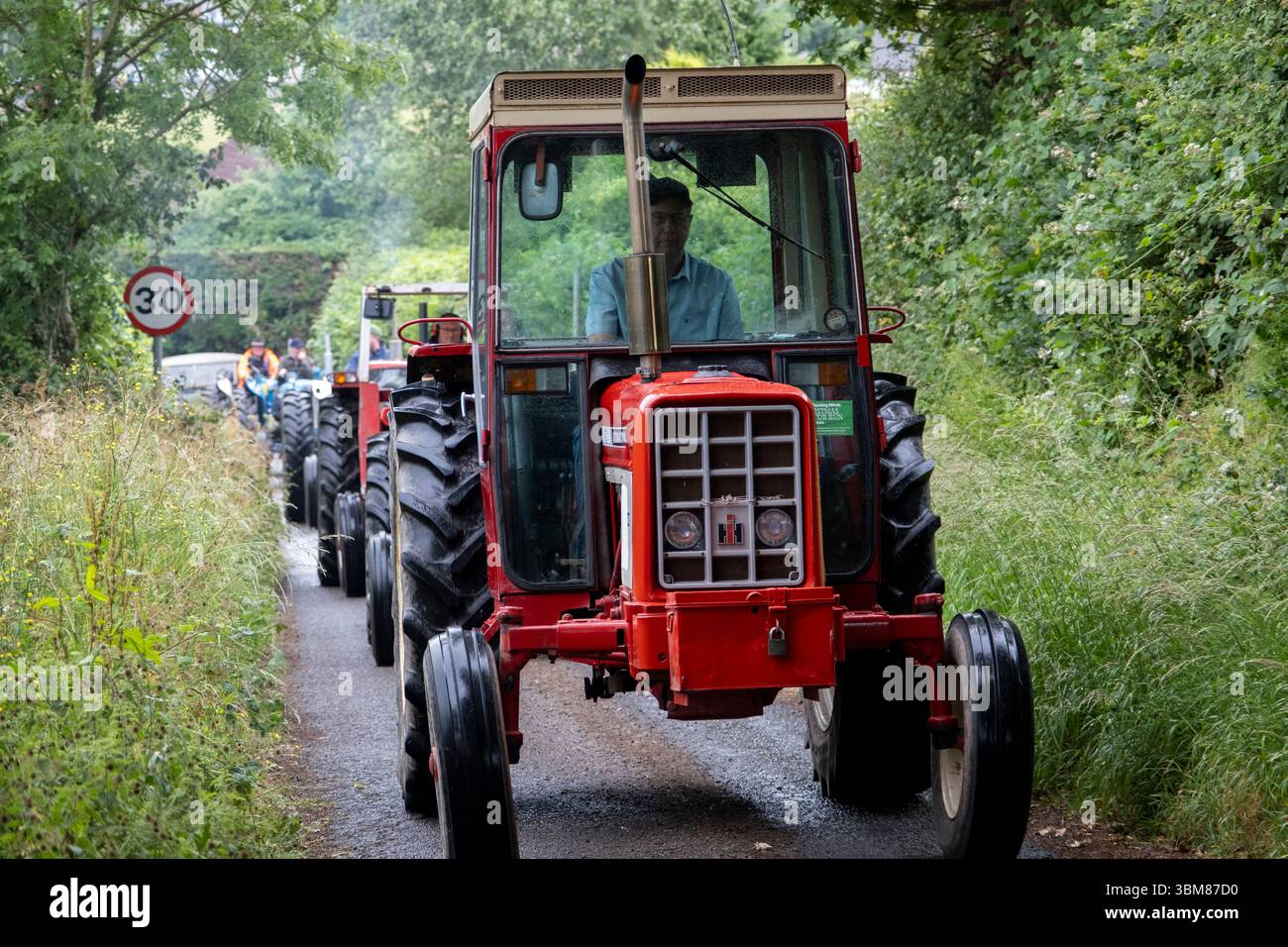 Trattore d'epoca in funzione il 22 giugno 2025 a Bucknell, Regno Unito. Un trattore è una corsa su strada, con numerosi trattori d'epoca o restaurati e alcuni trattori moderni. Gli eventi hanno spesso lo scopo caritatevole di raccogliere fondi per cause specifiche. Foto Stock
