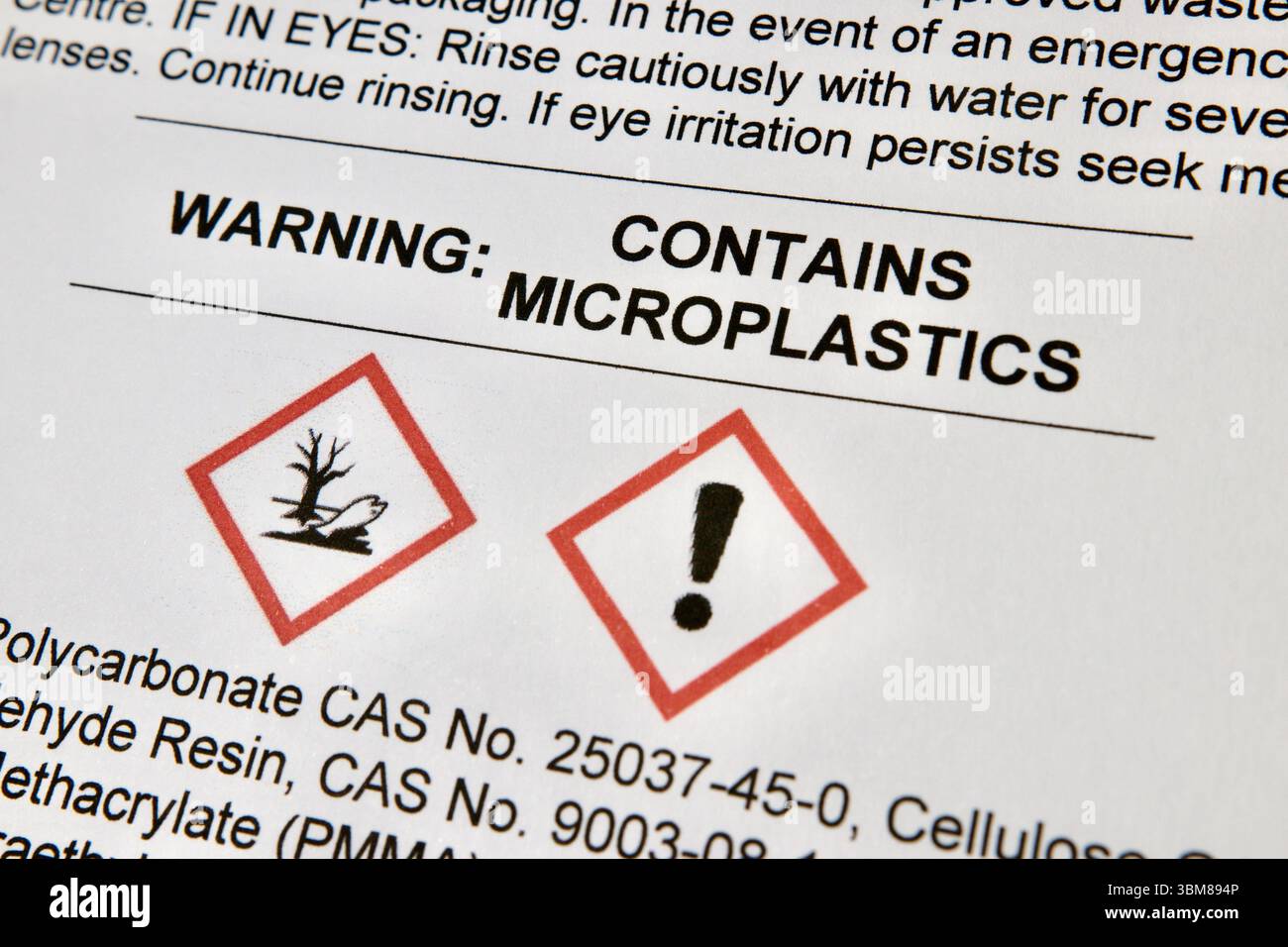 L'etichetta di avvertenza elenca gli ingredienti sintetici e le microplastiche, evidenziando i rischi ambientali di contaminazione delle microplastiche e danni ambientali Foto Stock