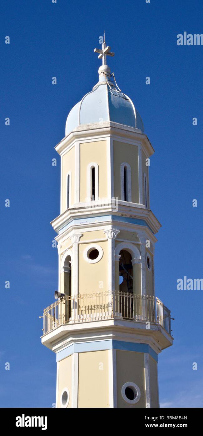Torre gialla della chiesa con finiture bianche e cupola blu adagiata su un cielo vibrante sull'isola di Cefalonia, in Grecia. Foto Stock