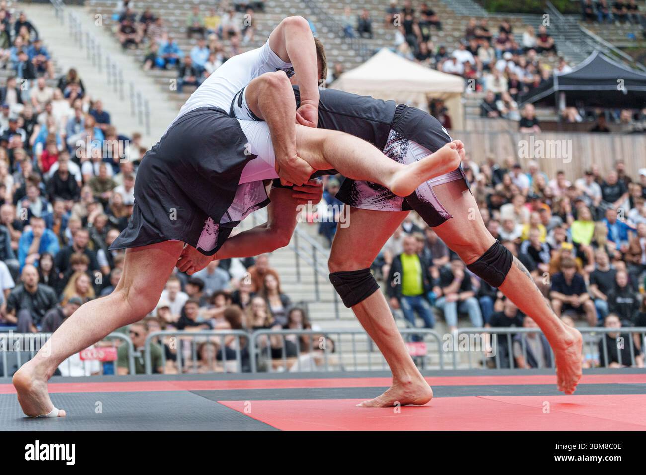Due atleti che gareggiano in una partita di jiu-jitsu BJJ brasiliana no-gi su un tappetino esterno. Foto di alta qualità Foto Stock