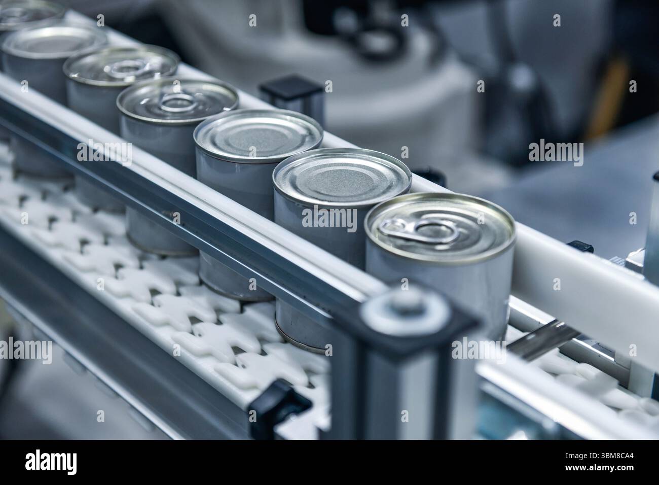 Prodotti alimentari in scatola su nastro trasportatore nel magazzino di distribuzione. Concetto del sistema di trasporto alimentare Foto Stock
