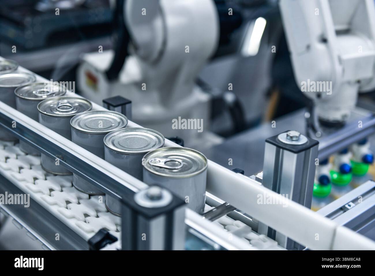Prodotti alimentari in scatola su nastro trasportatore nel magazzino di distribuzione. Concetto del sistema di trasporto alimentare Foto Stock
