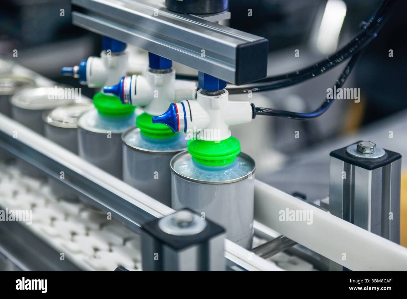 Prodotti alimentari in scatola su nastro trasportatore nel magazzino di distribuzione. Concetto del sistema di trasporto alimentare Foto Stock