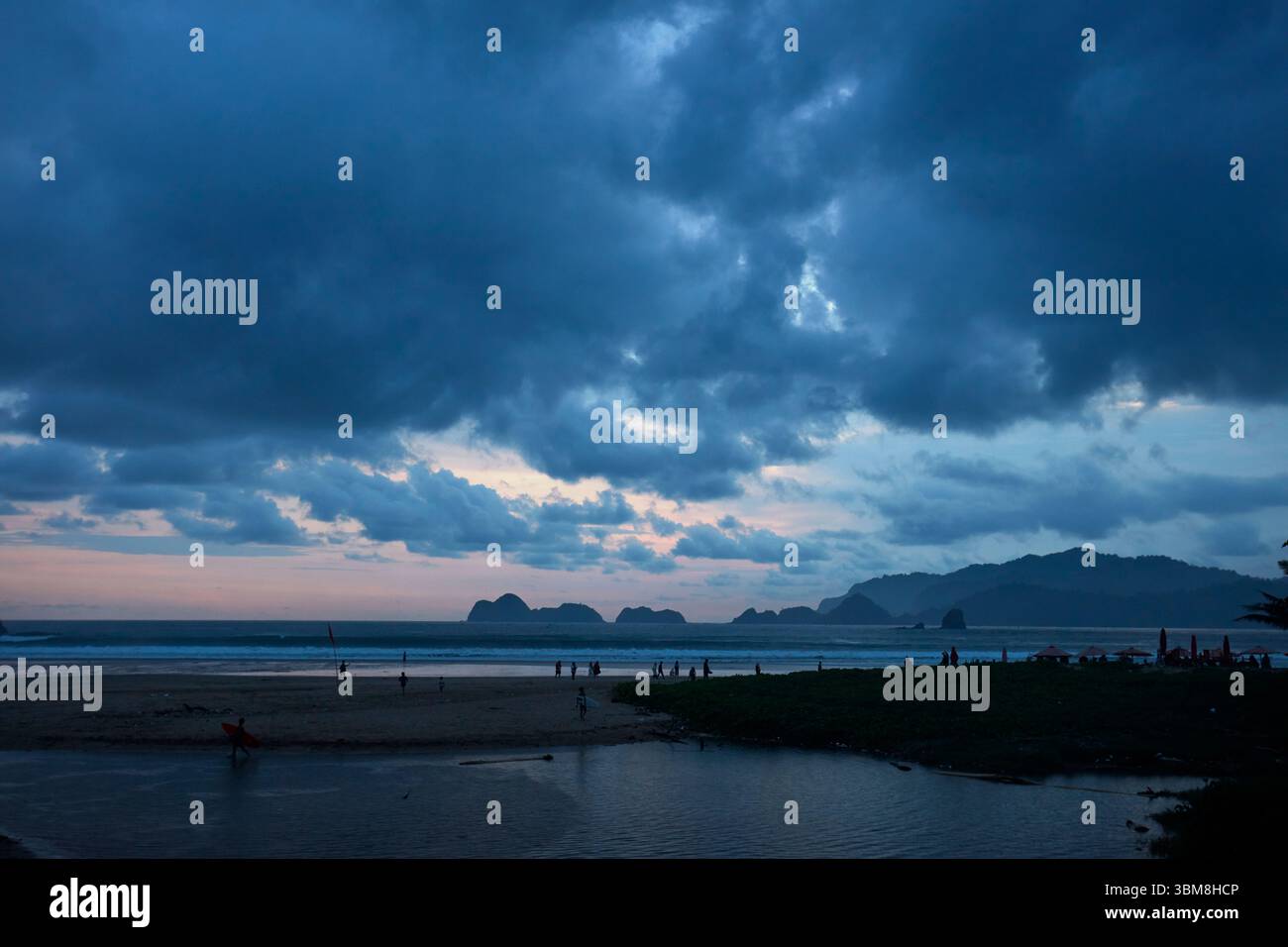 Persone sulla spiaggia al tramonto, Pulau Merah (Spiaggia dell'Isola Rossa), Giava Orientale, Indonesia Foto Stock