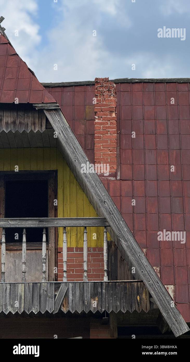 Balcone in legno rustico e Camino in mattoni del vecchio cottage - dettaglio architettonico di campagna d'epoca - Immagine stock catturata con smartphone