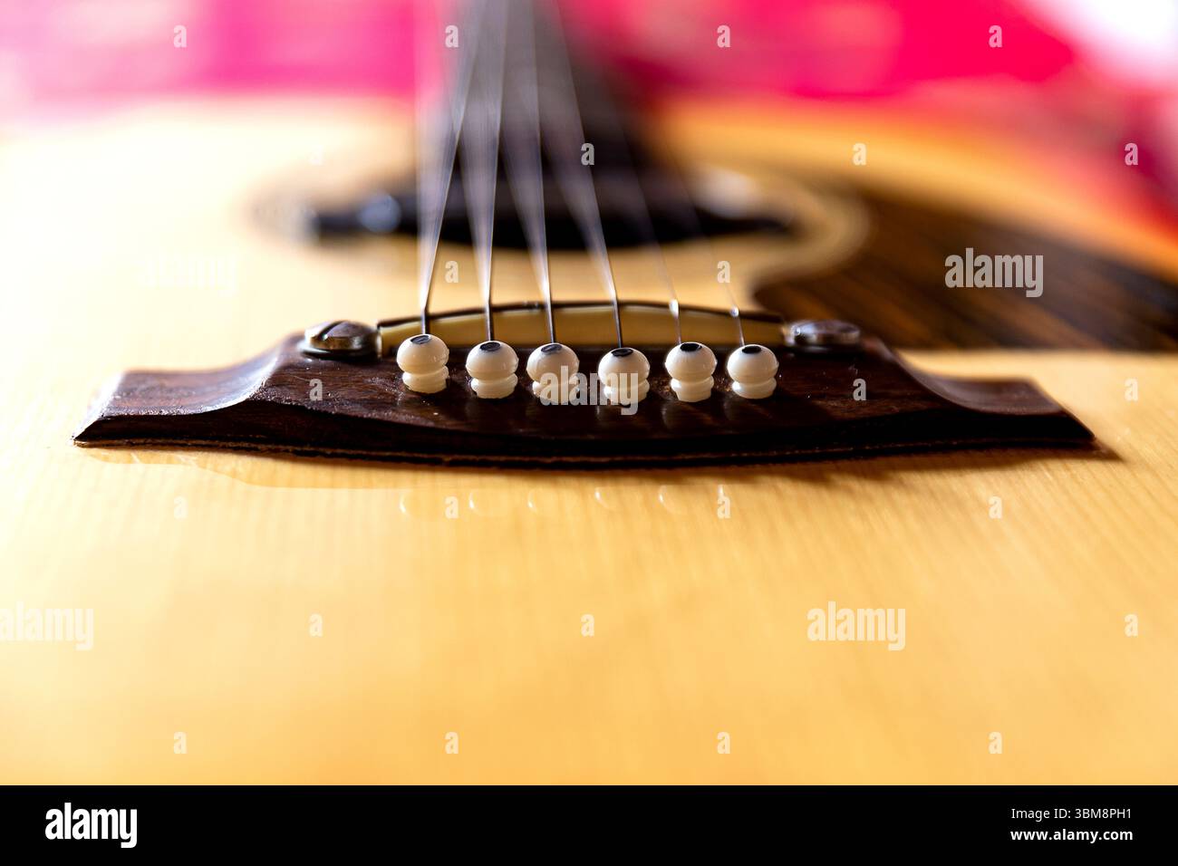 Una vista ravvicinata di una chitarra acustica classica, che mostra il suo corpo in legno, le corde e la cura artigianale dettagliata. Foto Stock