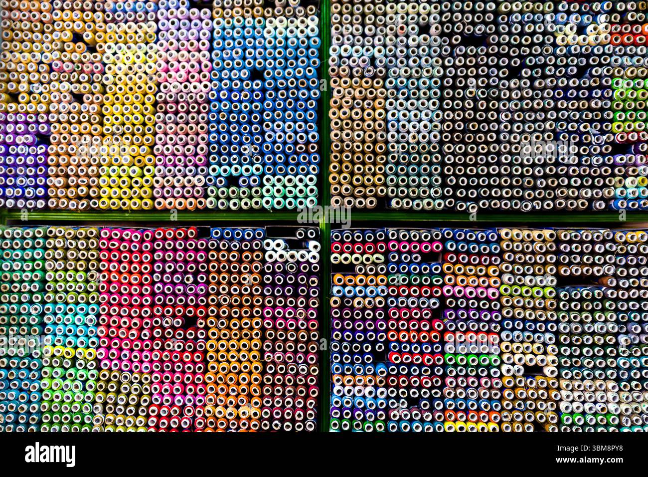 Un negozio di artigianato presenta una serie di forniture d'arte accuratamente organizzate per colore. Foto Stock