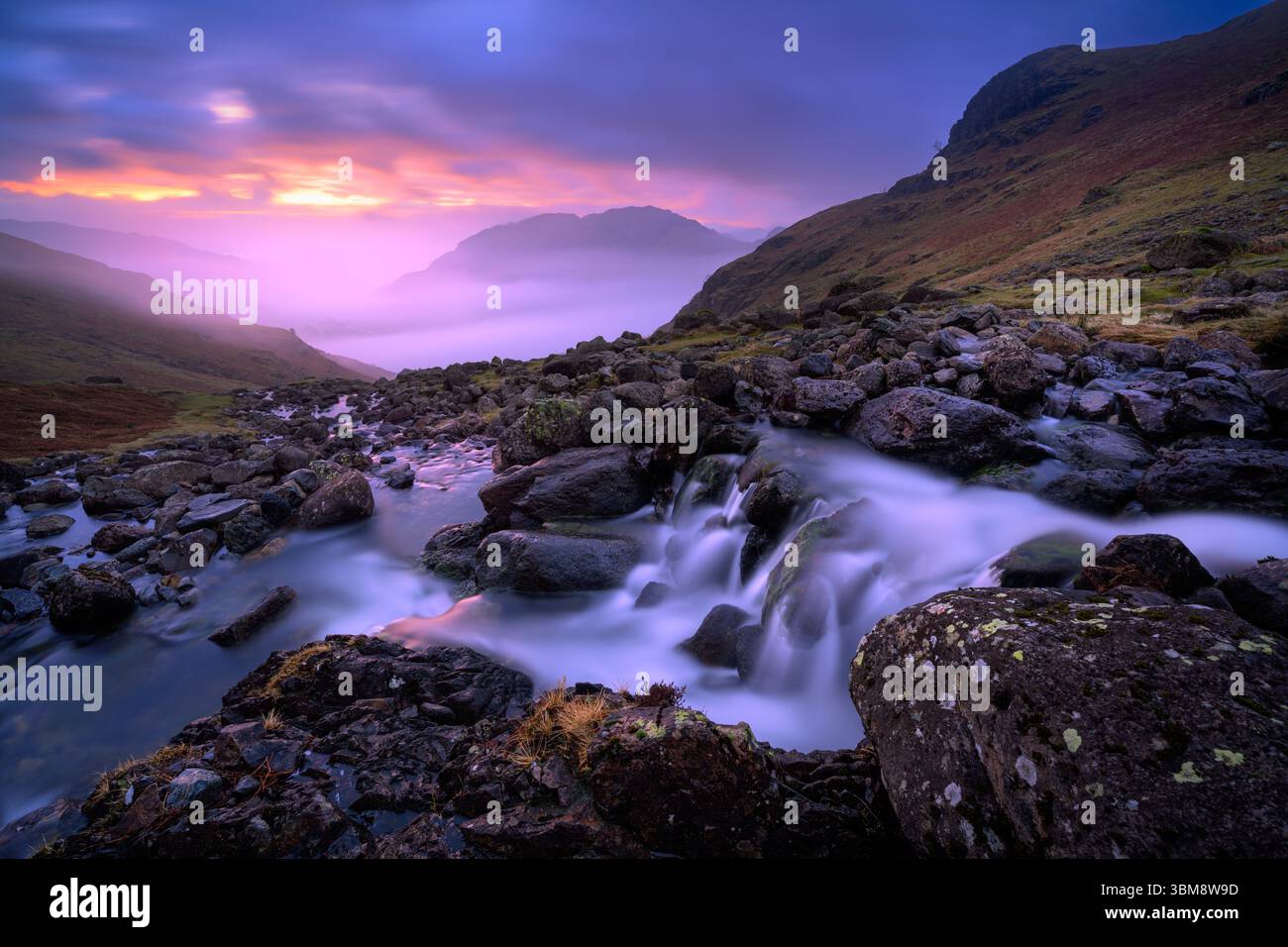 Splendida alba nebbiosa con cascata di montagna che si affaccia sulla Langdale Valley nel Lake District, Regno Unito. Foto Stock