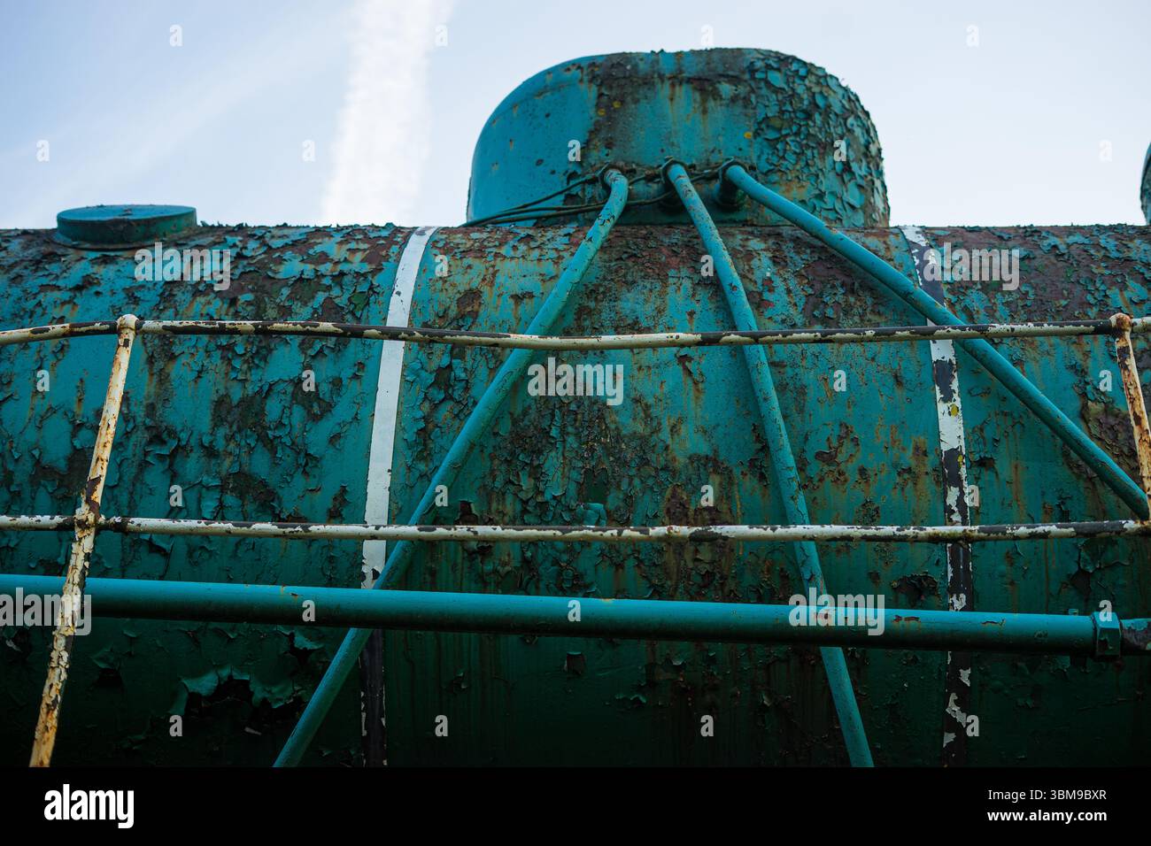 Primo piano di un serbatoio industriale arrugginito con vernice sbucciante Foto Stock