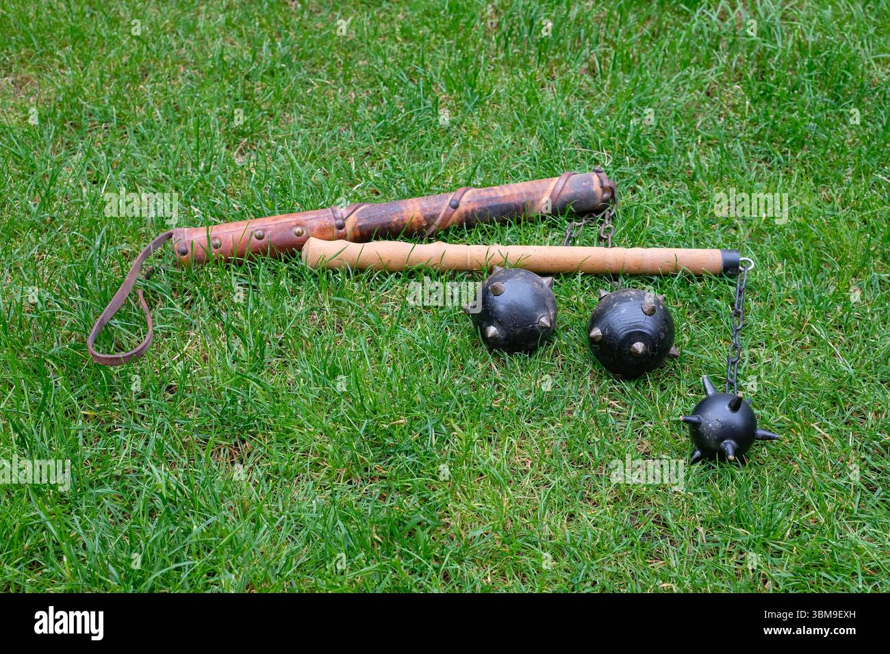 L'arma decorativa medievale o la mazza Morgenstern con punte giace sull'erba verde. Arti marziali e tornei. Foto Stock