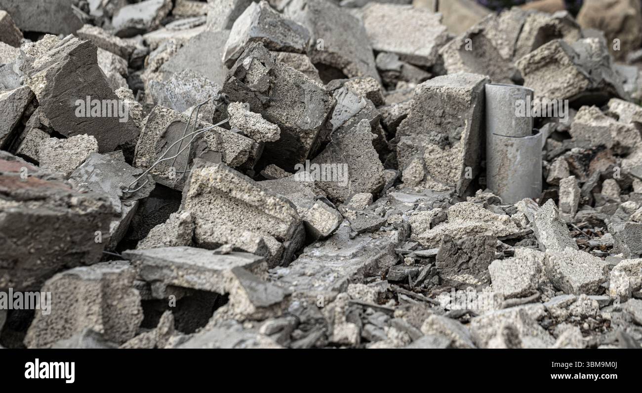 Macerie e detriti di calcestruzzo derivanti dalla demolizione di edifici, con tubi rotti e tondini esposti Foto Stock