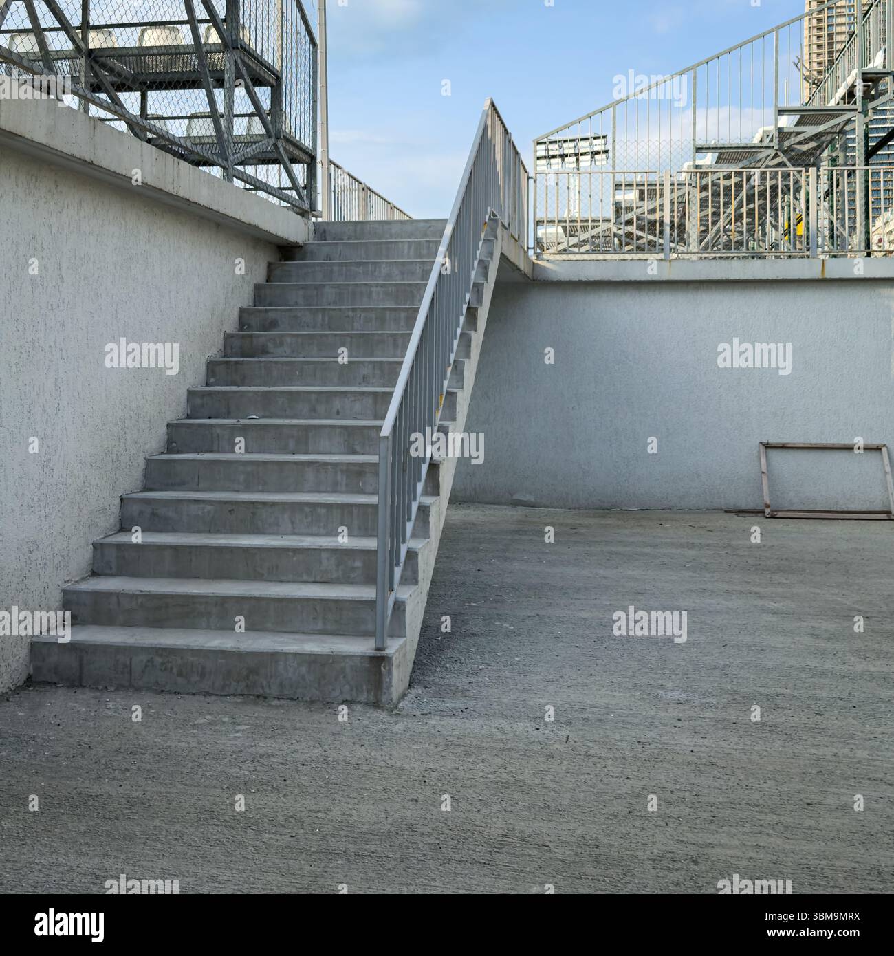 Scala in cemento con ringhiera in metallo in un ambiente urbano minimalista, vista frontale. Niente persone. Adatto per uso concettuale o editoriale. Foto Stock