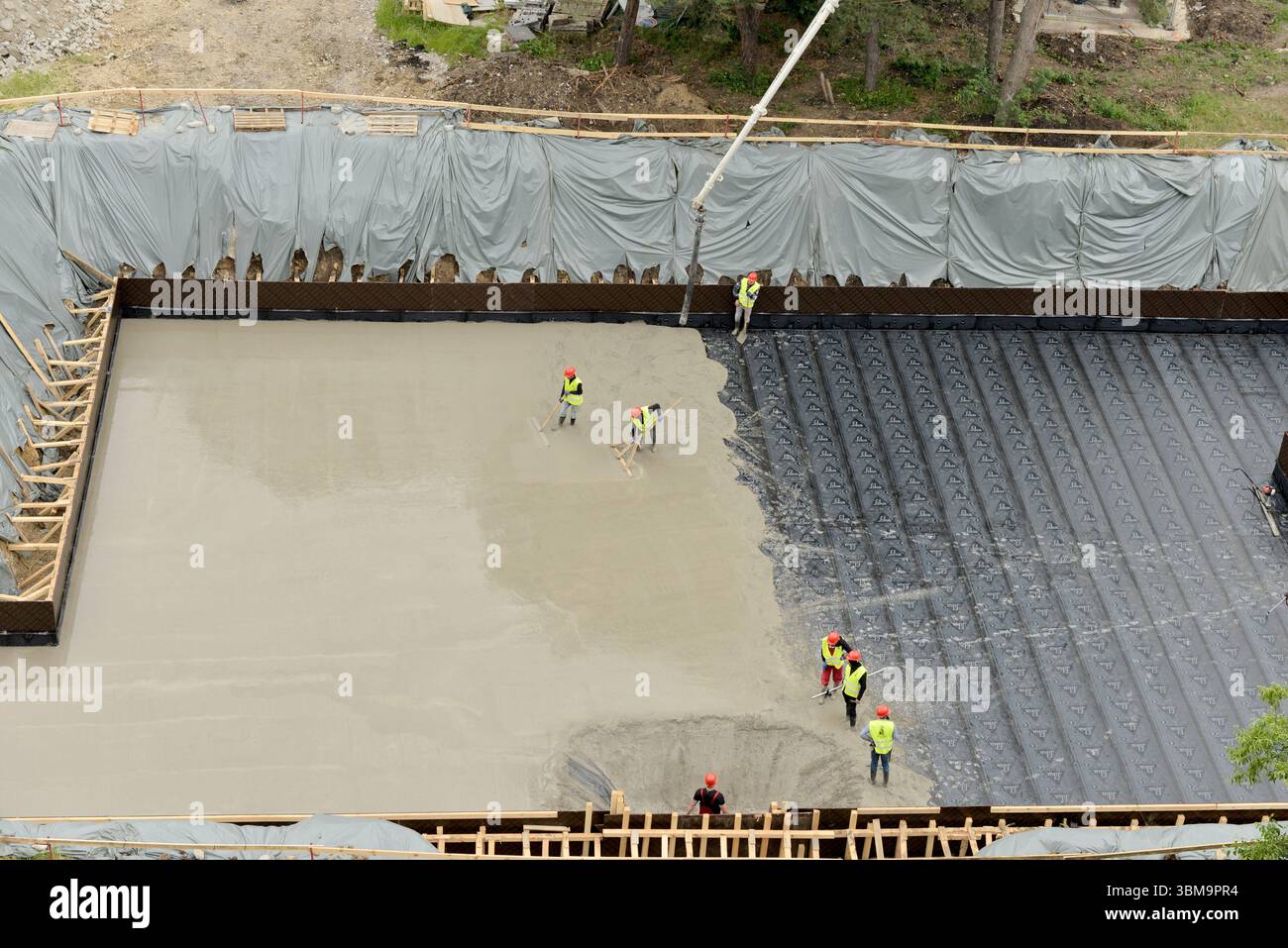 Versamento di calcestruzzo su lastre isolanti nel cantiere, tecniche di costruzione moderne e lavori di fondazione efficienti dal punto di vista energetico Foto Stock