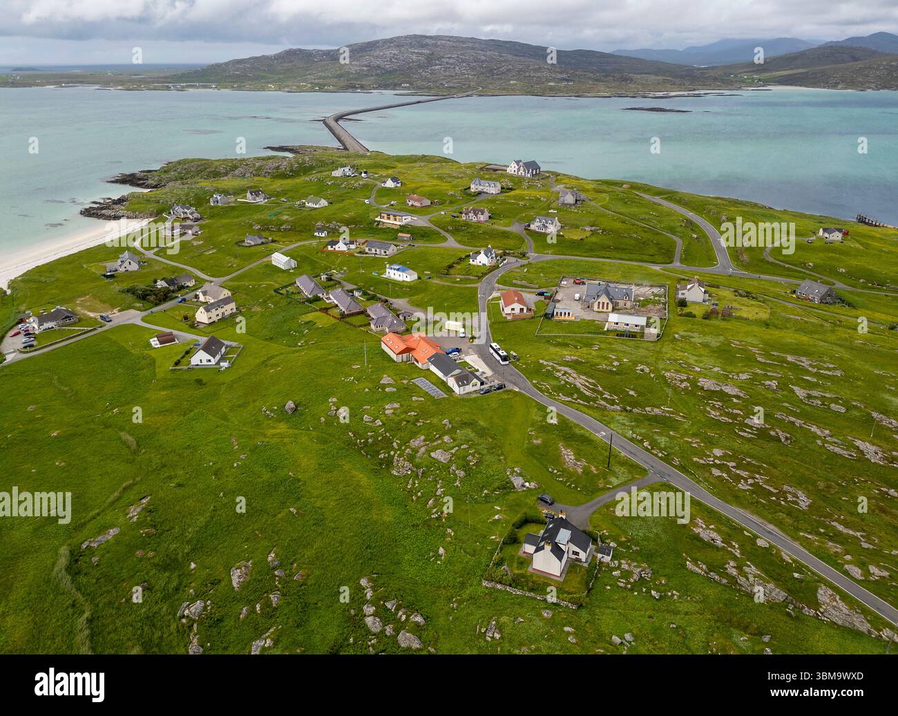 Vista aerea con droni della cittadina dell'Isola di Eriskay che mostra la strada rialzata di Eriskay che collega l'isola a South Uist, Ebridi esterne, Scozia Foto Stock