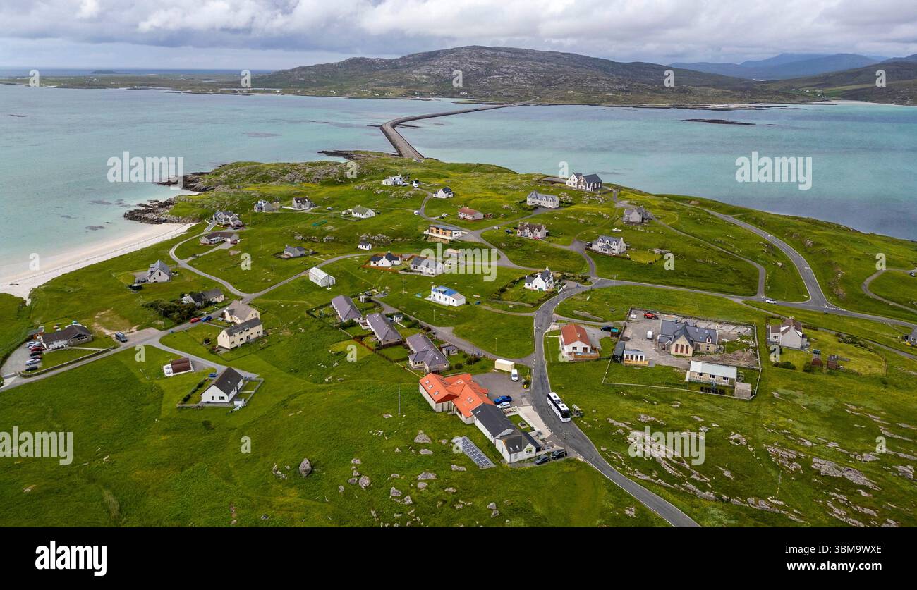 Vista aerea con droni della cittadina dell'Isola di Eriskay che mostra la strada rialzata di Eriskay che collega l'isola a South Uist, Ebridi esterne, Scozia Foto Stock