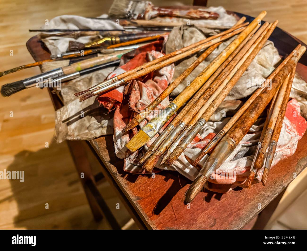 Pennelli e stracci su una superficie di legno in uno studio di artisti, che mostrano l'inconveniente del processo creativo. Foto Stock
