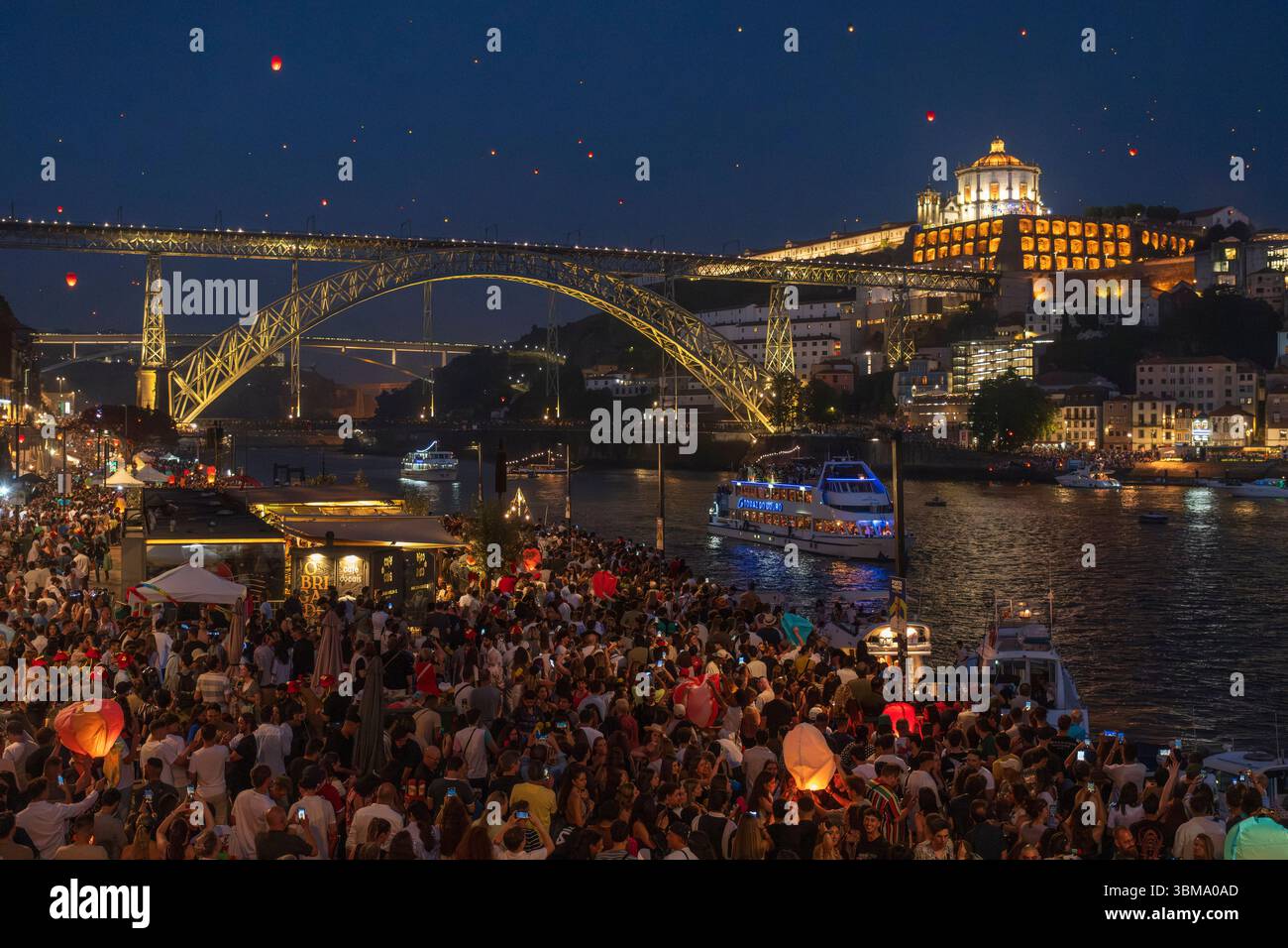 Porto di notte in un tripudio di luce: Durante il tradizionale festival di Sao Joao, la città si trasforma in un mare colorato di lanterne e fuochi d'artificio Foto Stock