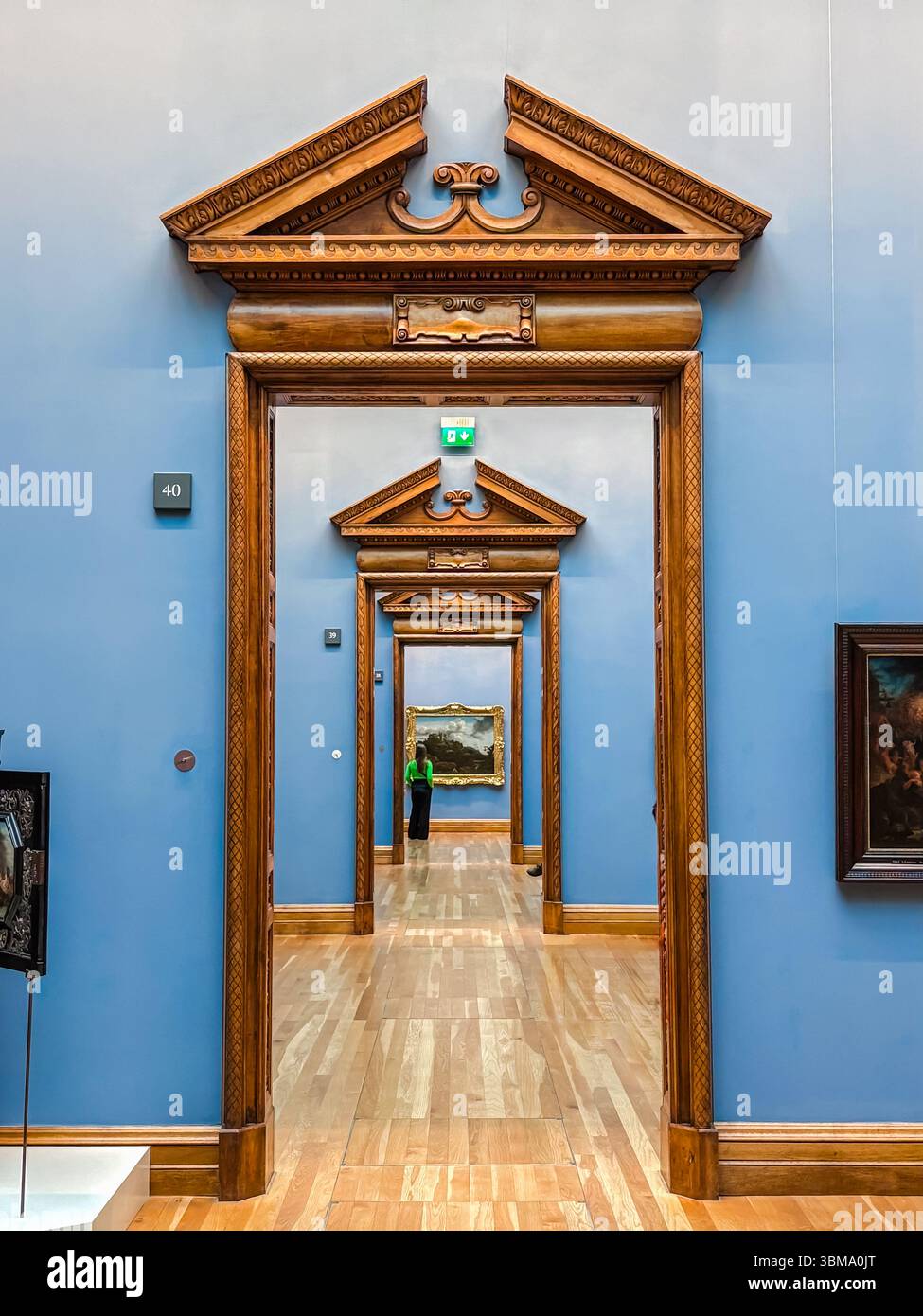 National Gallery, Dublino. Porte in legno ripetitive e ornate in una galleria museo con pareti blu e pavimenti in legno chiaro. Foto Stock