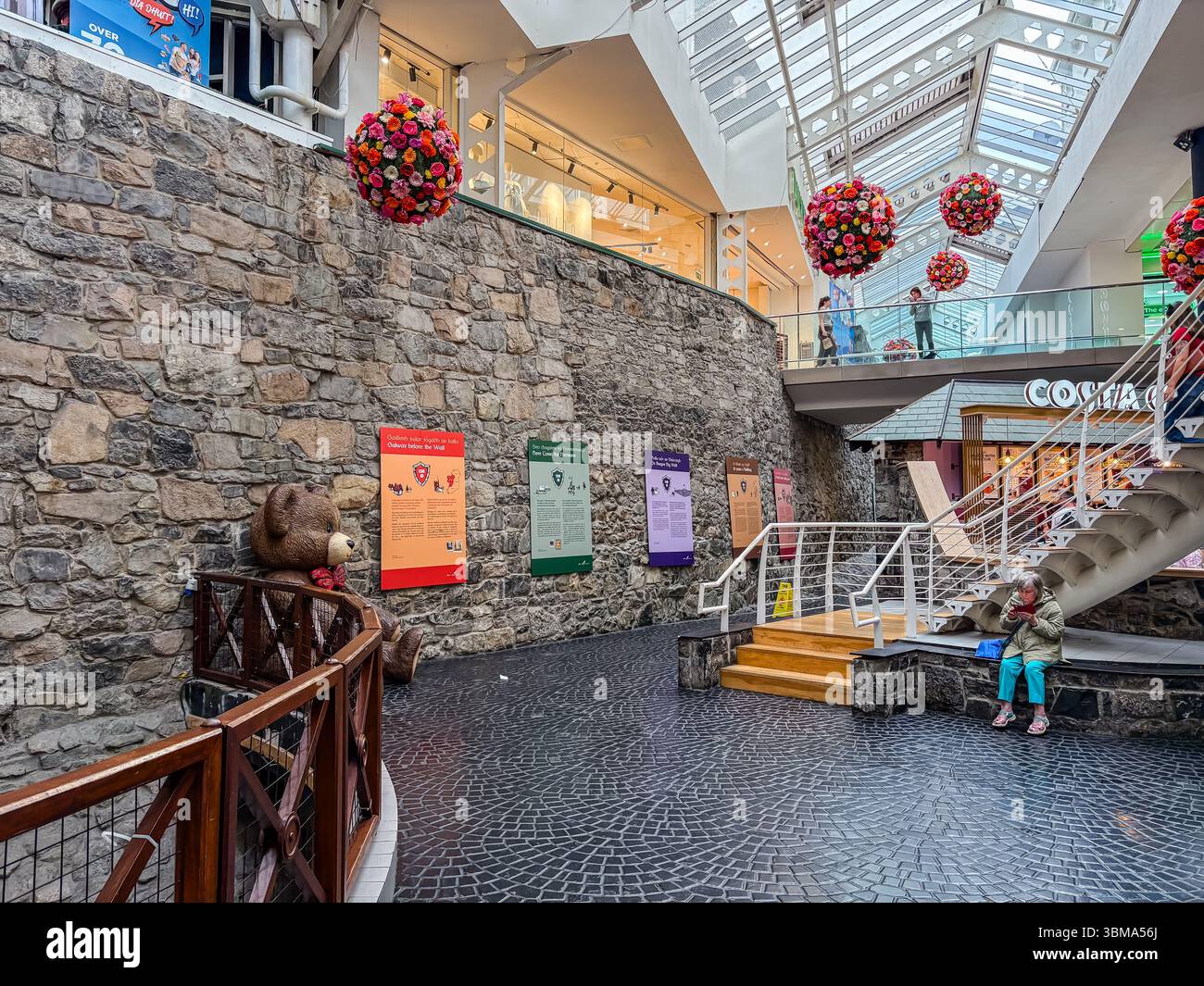 Vista interna di Eyre Square Centre che mostra le mura della città vecchia conservate integrate con moderni spazi commerciali, passaggi pedonali e scale a Galway, Irlanda. Foto Stock Vista interna di Eyre Square Centre che mostra le mura della città vecchia conservate integrate con moderni spazi commerciali, passaggi pedonali e scale a Galway, Irlanda. Foto Stock