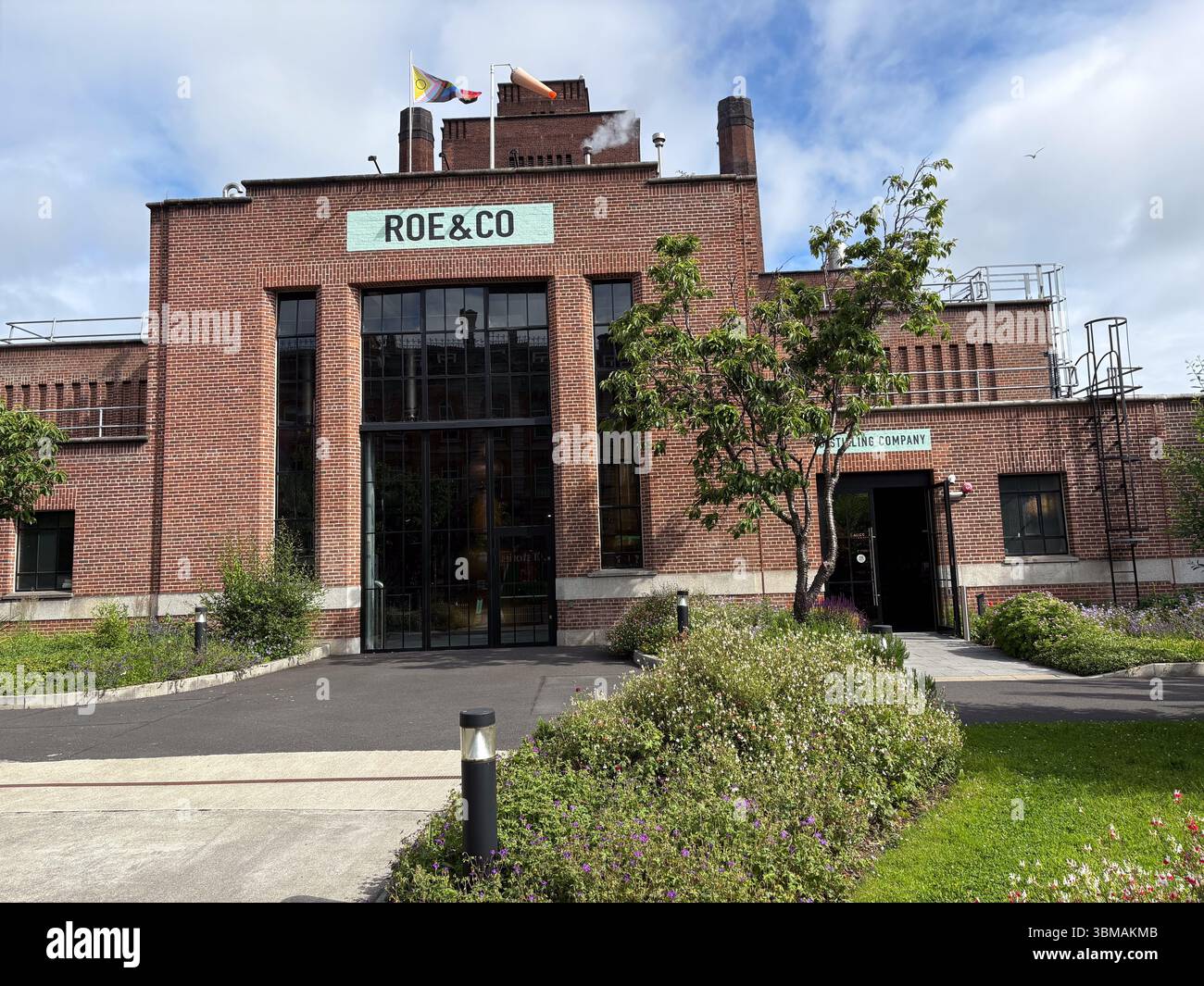 Distilleria Roe & Co. Vista della facciata dell'edificio in mattoni rossi con moderna entrata in vetro a Dublino, Irlanda. Offre un'architettura paesaggistica. Foto Stock
