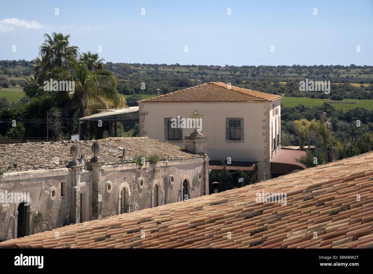Le splendide viste di Ragusa, i tetti in terracotta e la vegetazione lussureggiante sotto un cielo blu invitano a esplorare e rilassarsi in Sicilia, Italia Foto Stock