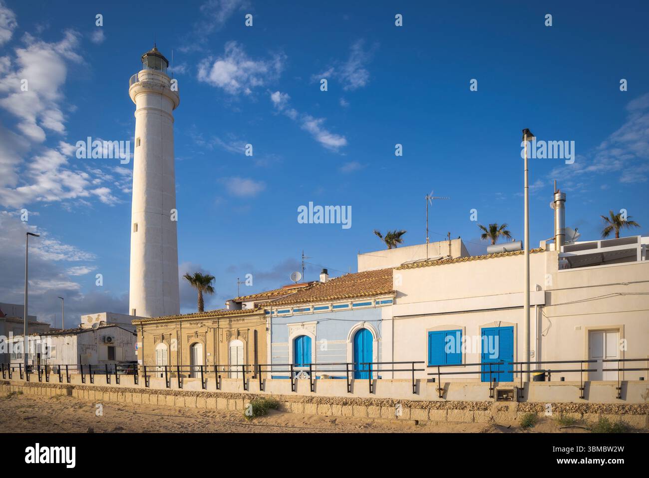 L'ora d'oro illumina il faro di Punta secca e gli edifici colorati, creando un'atmosfera magica in Sicilia, Italia Foto Stock