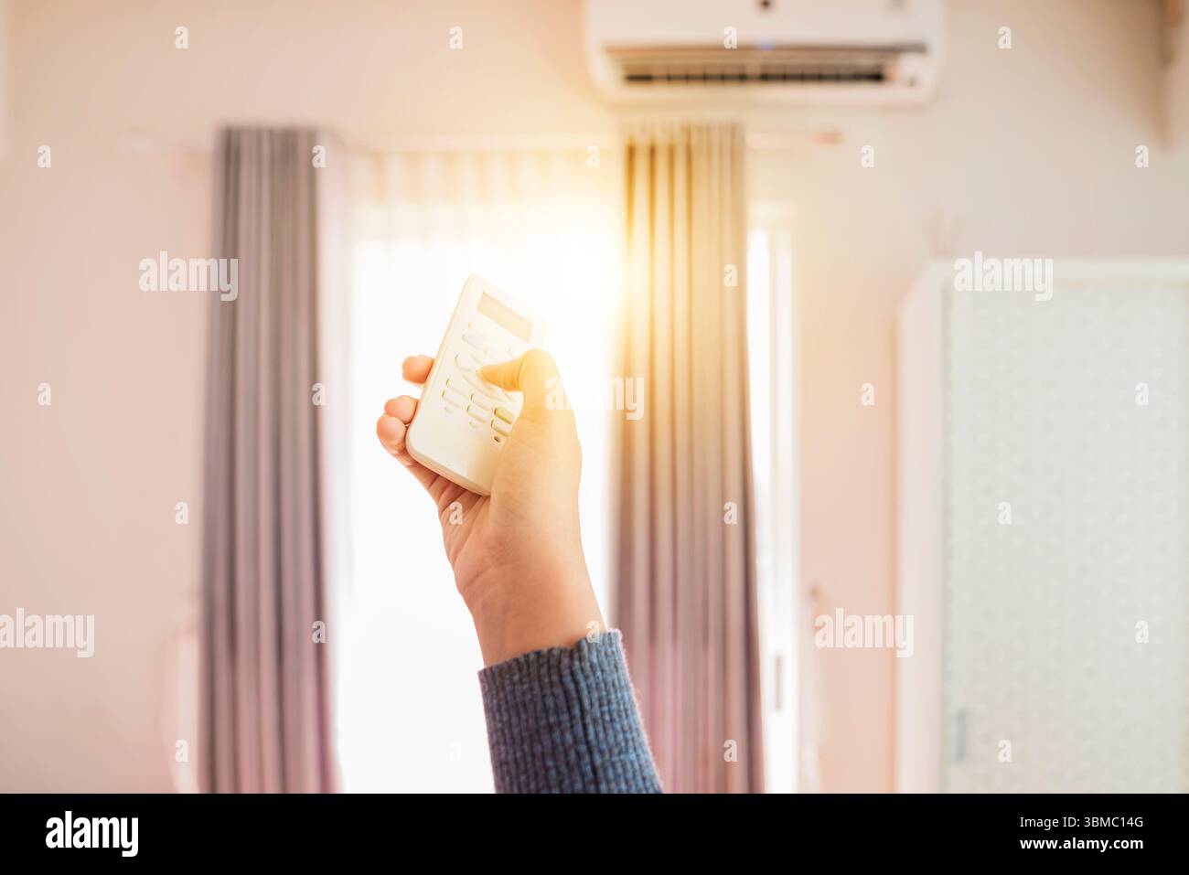 Woman Hand spegne il condizionatore d'aria in camera la mattina. Concetto di autocura e routine di benessere Foto Stock