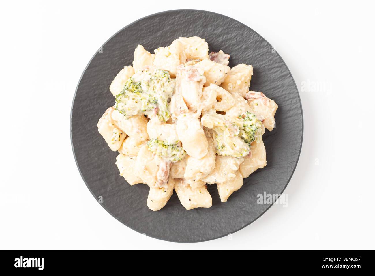 Torta di riso coreana Tteokbokki con pancetta e broccoli su sfondo bianco Foto Stock
