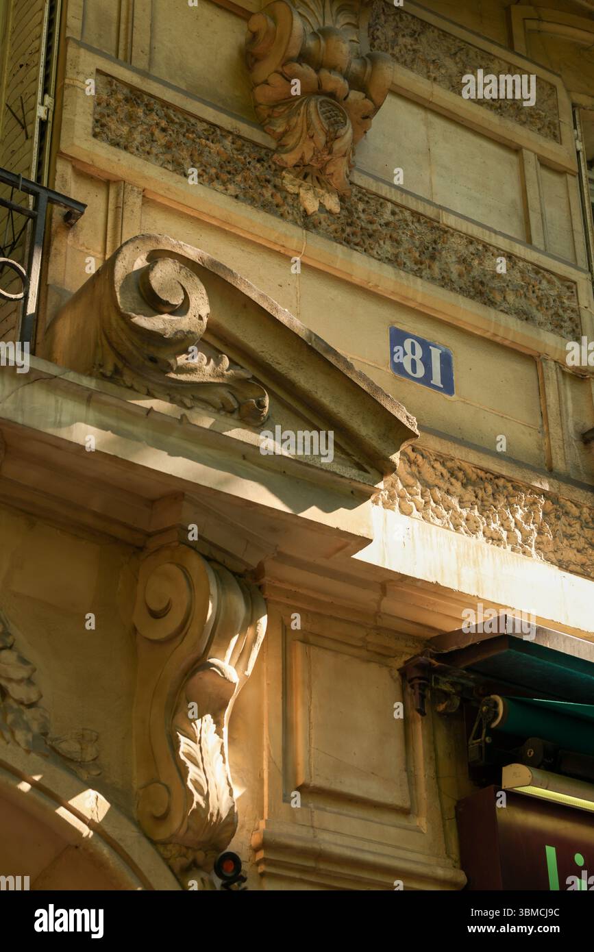 Una fotografia ravvicinata che mostra l'intricata muratura di pietra di un edificio parigino. Foto Stock