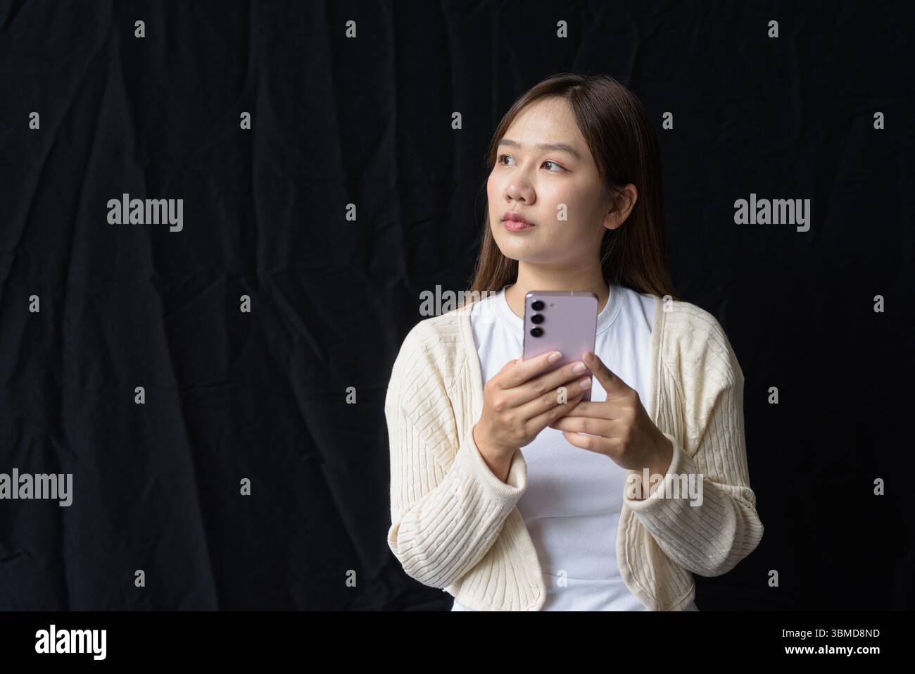 Ritratto in studio di una giovane donna asiatica su sfondo scuro Foto Stock