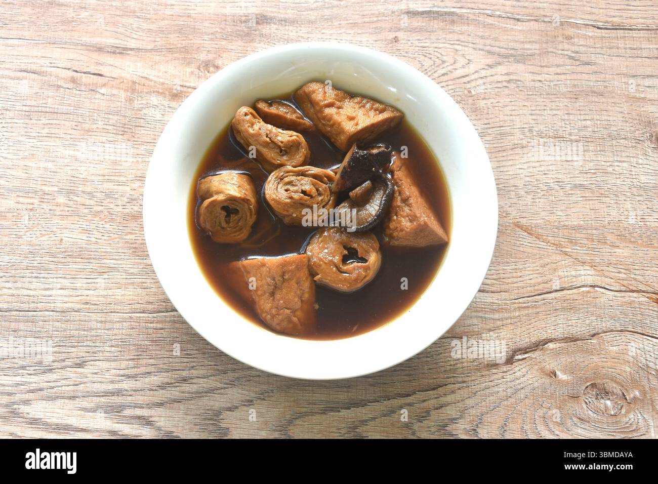 fetta bollita di tofu e glutine con zuppa di funghi neri alle erbe e cibo vegetariano nella ciotola Foto Stock