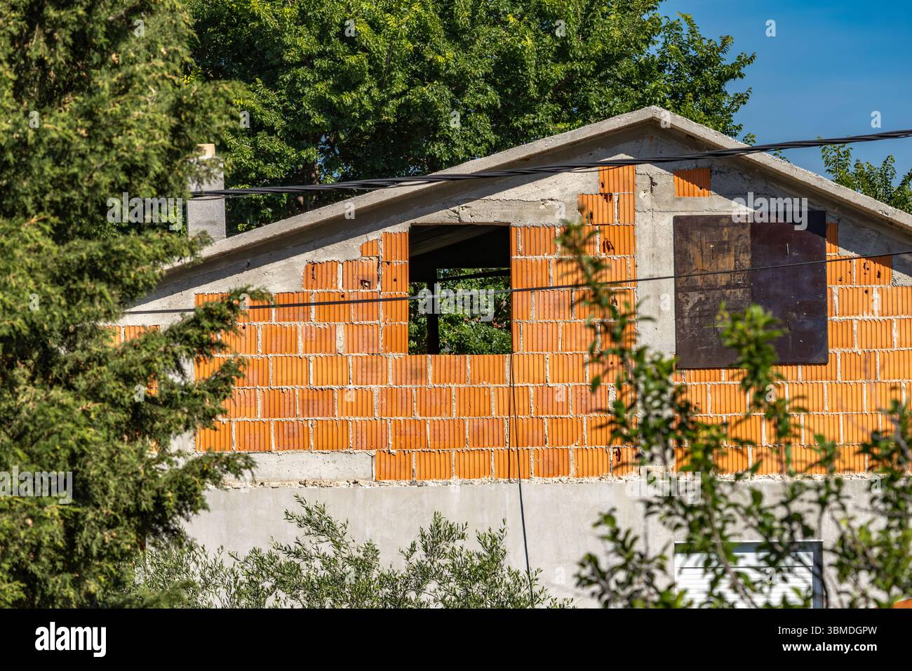Costruire una casa in mattoni rossi, investire in appartamenti in affitto ai turisti, edificio incompiuto Foto Stock