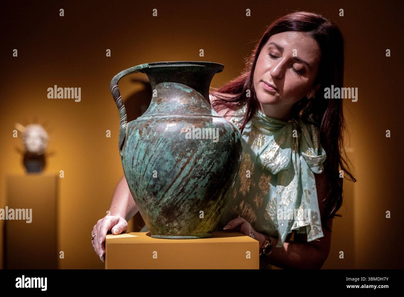 Londra, Regno Unito. 26 giugno 2025. Membro della galleria con «Una grande brocca romana di bronzo», circa i-IV secolo d.C., presso lo stand della Kallos Gallery all'apertura della Treasure House Fair presso il Royal Hospital Chelsea. La fiera presenta arte, antiquariato e design di settanta dei migliori commercianti britannici e internazionali ed è aperta al pubblico dal 26 giugno al 1° luglio 2025. Crediti: Stephen Chung / Alamy Live News Foto Stock