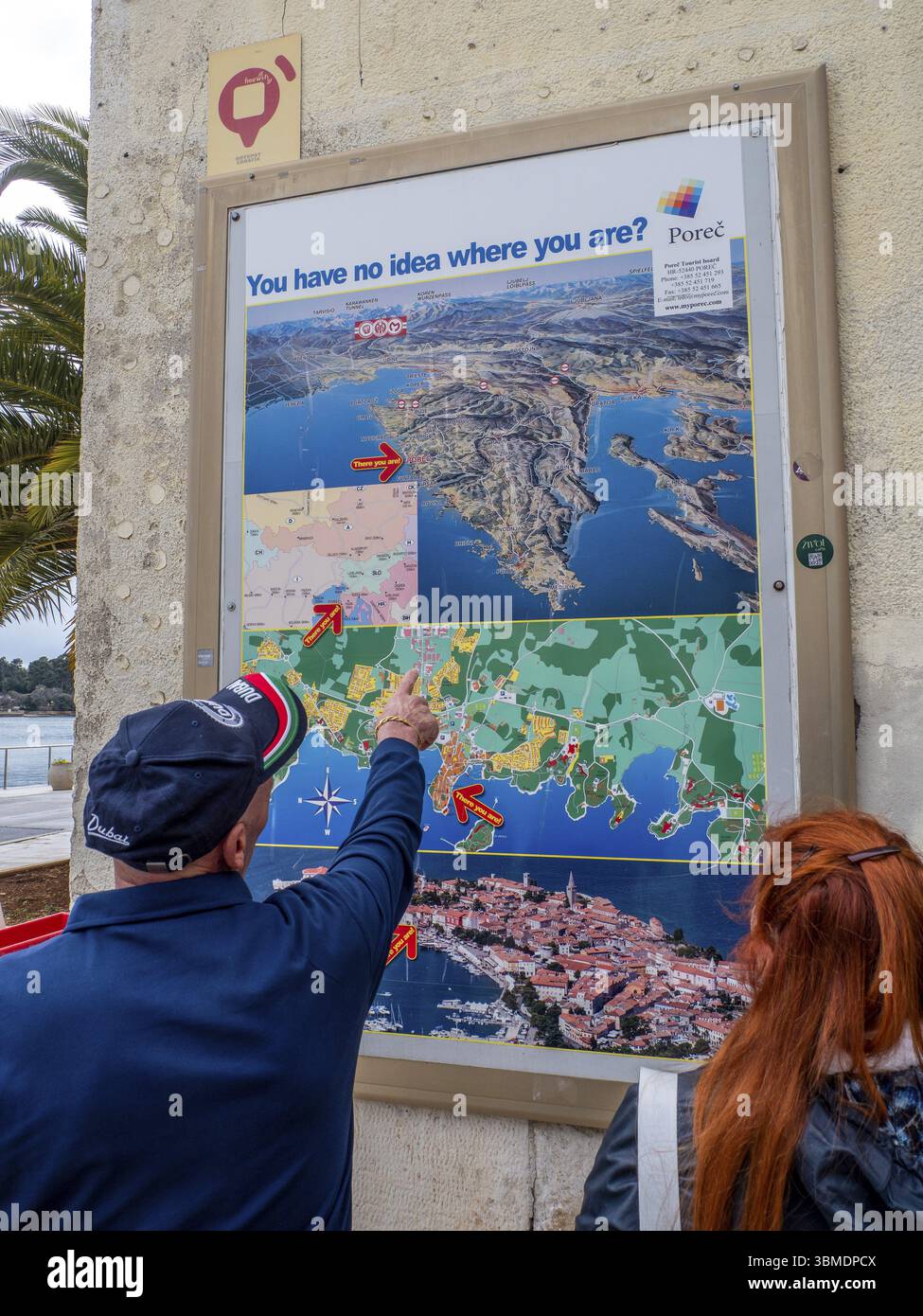 Un uomo indica una mappa con la città di Parenzo in Istria su un muro di casa, Parenzo, Istria, Croazia, Europa Foto Stock