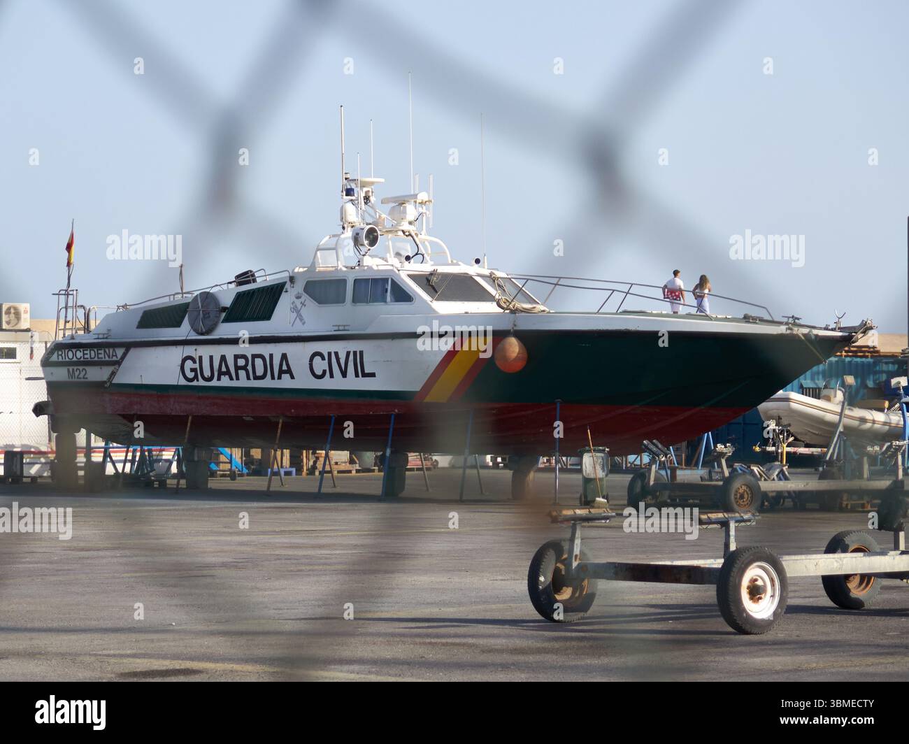 Benalmádena Costa, Málaga, Spagna - 25 giugno 2025: Vista dall'acqua attraverso una recinzione di una nave della Guardia Civil. Foto Stock