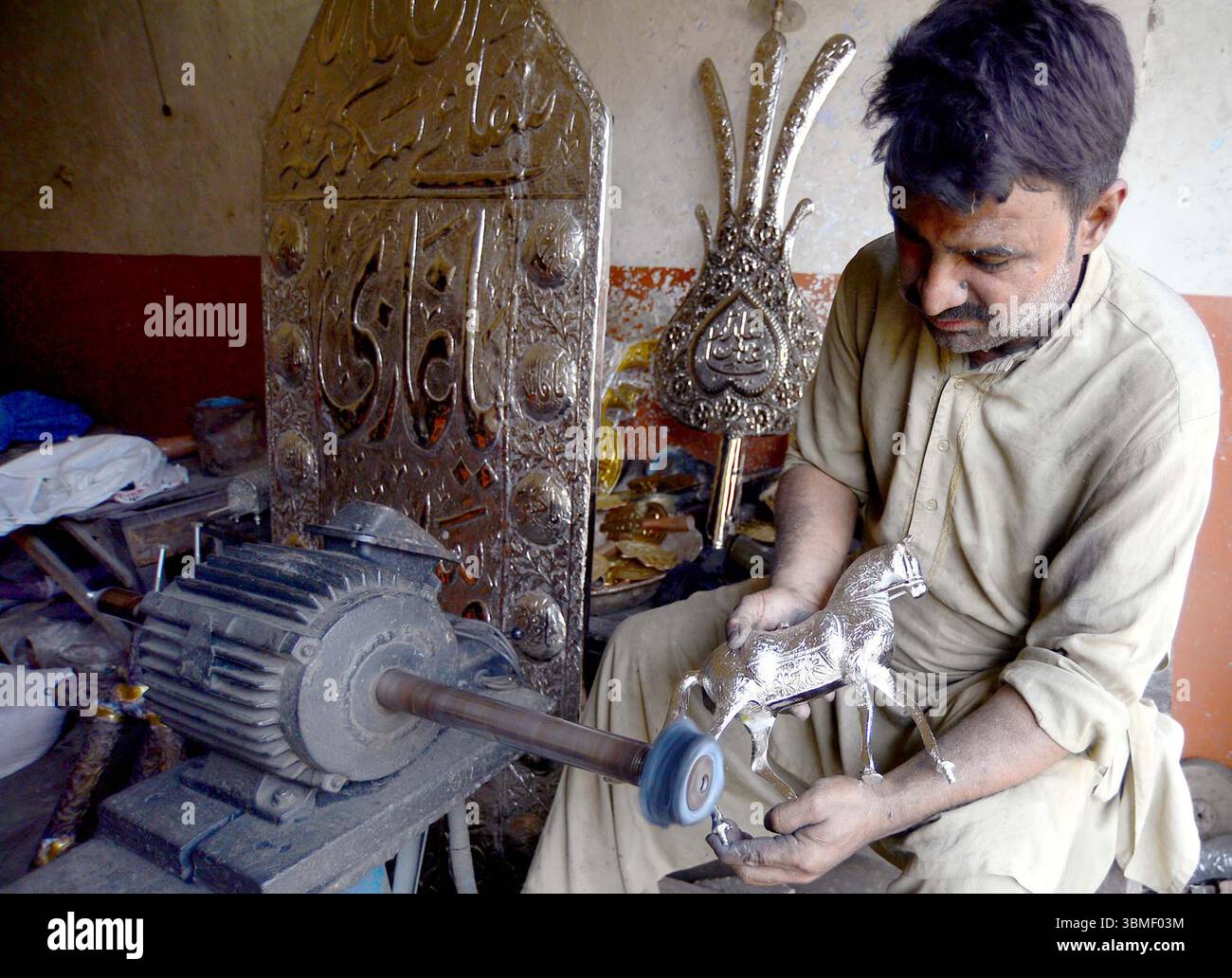I laburisti impegnati nella lucidatura degli azadari all'arrivo del mese Santo di Muharram-ul-Haram, sul posto di lavoro a Karachi giovedì 26 giugno 2025. Foto Stock