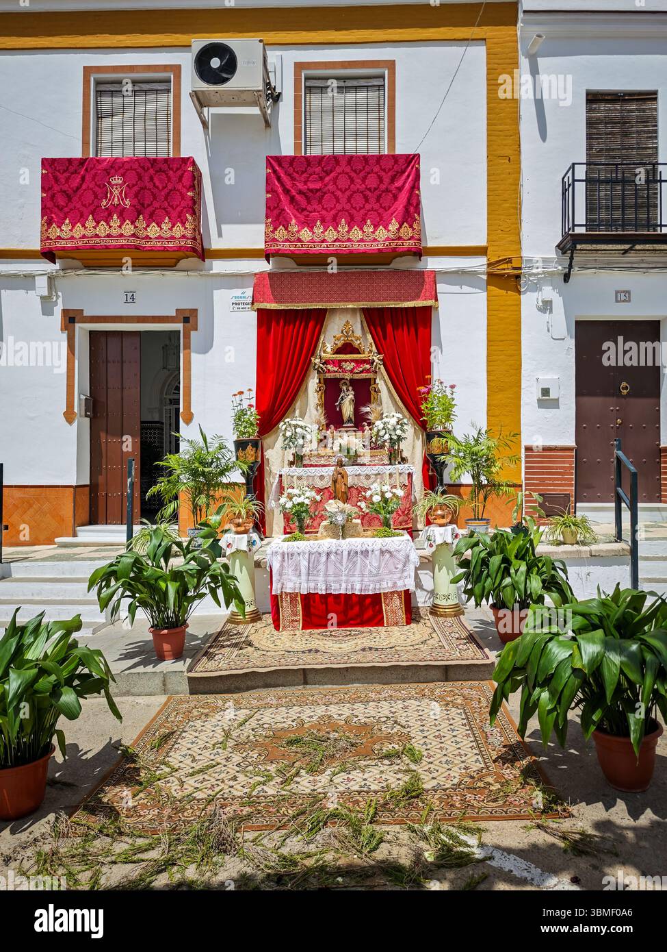 Un altare è elegantemente esposto a Carrión, Siviglia, adornato con fiori, velluti e icone sacre per il Corpus Domini. Foto Stock
