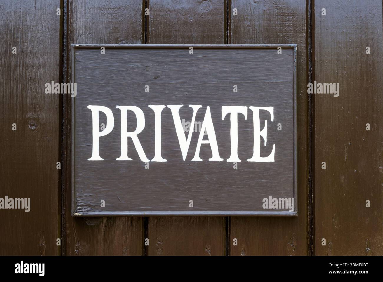 Insegna privata dipinta a mano su una porta di legno. Foto Stock