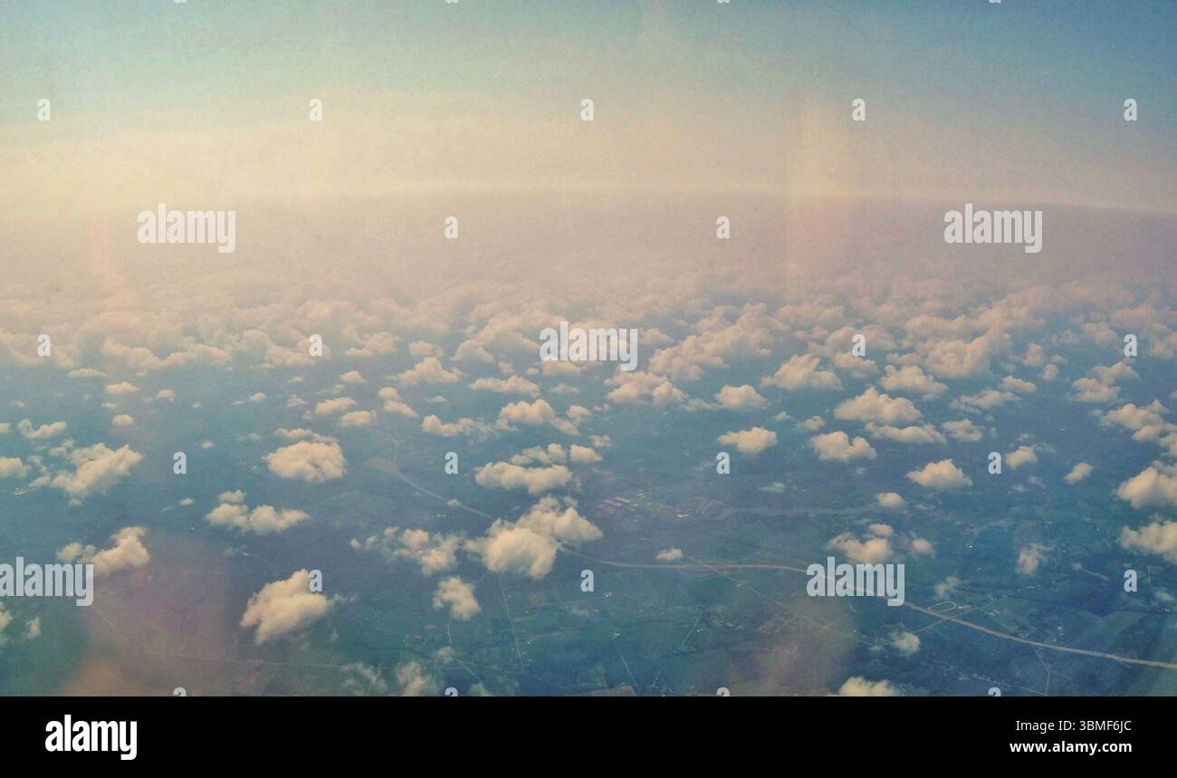 Un'accattivante vista aerea di un panorama panoramico con nuvole bianche sparse sulla terra. La scena evoca tranquillità e la bellezza infinita della natura Foto Stock