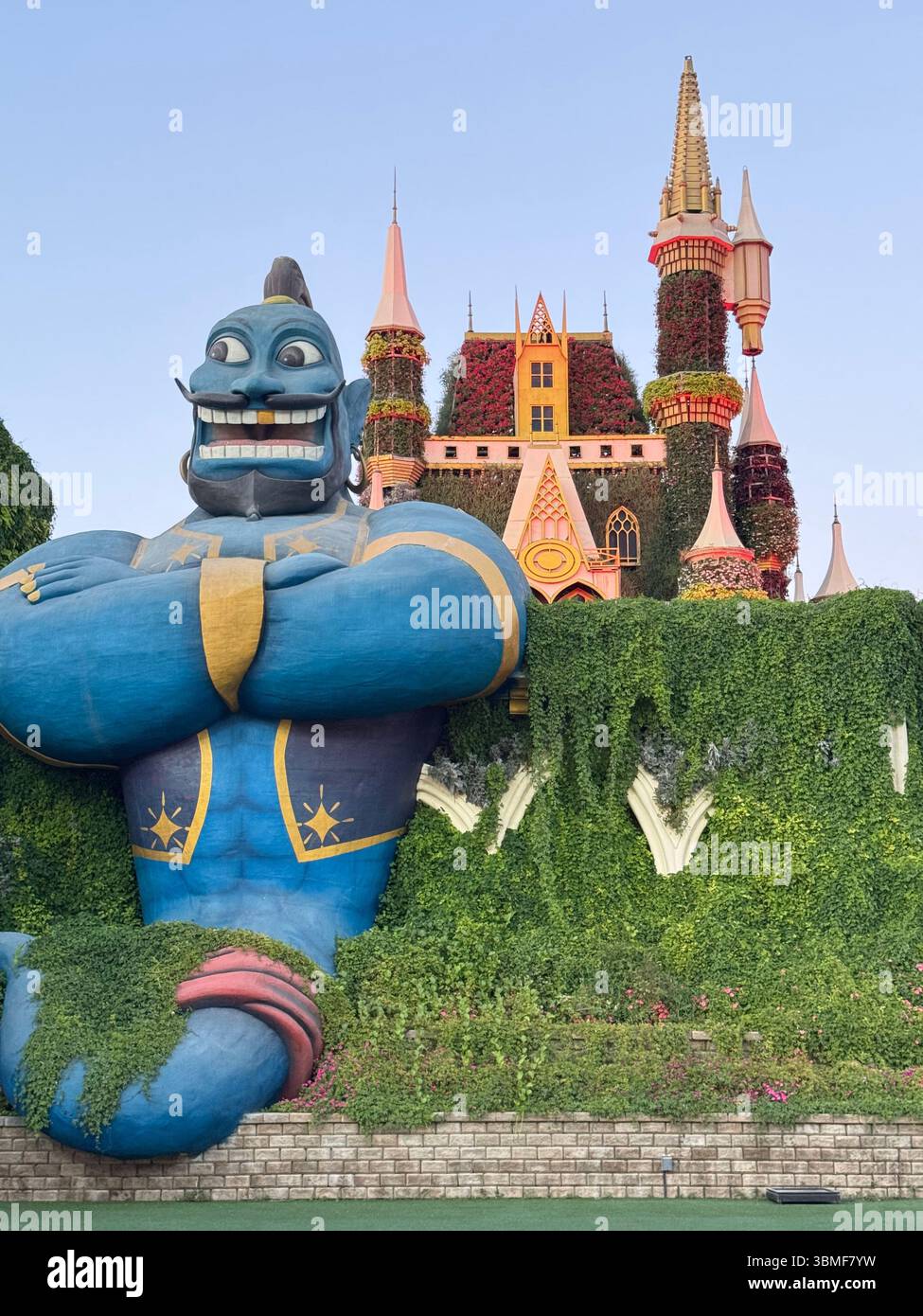 Il Genio di Aladino si erge alto davanti al castello e protegge con molta vegetazione sullo sfondo - Immagine stock catturata con smartphone