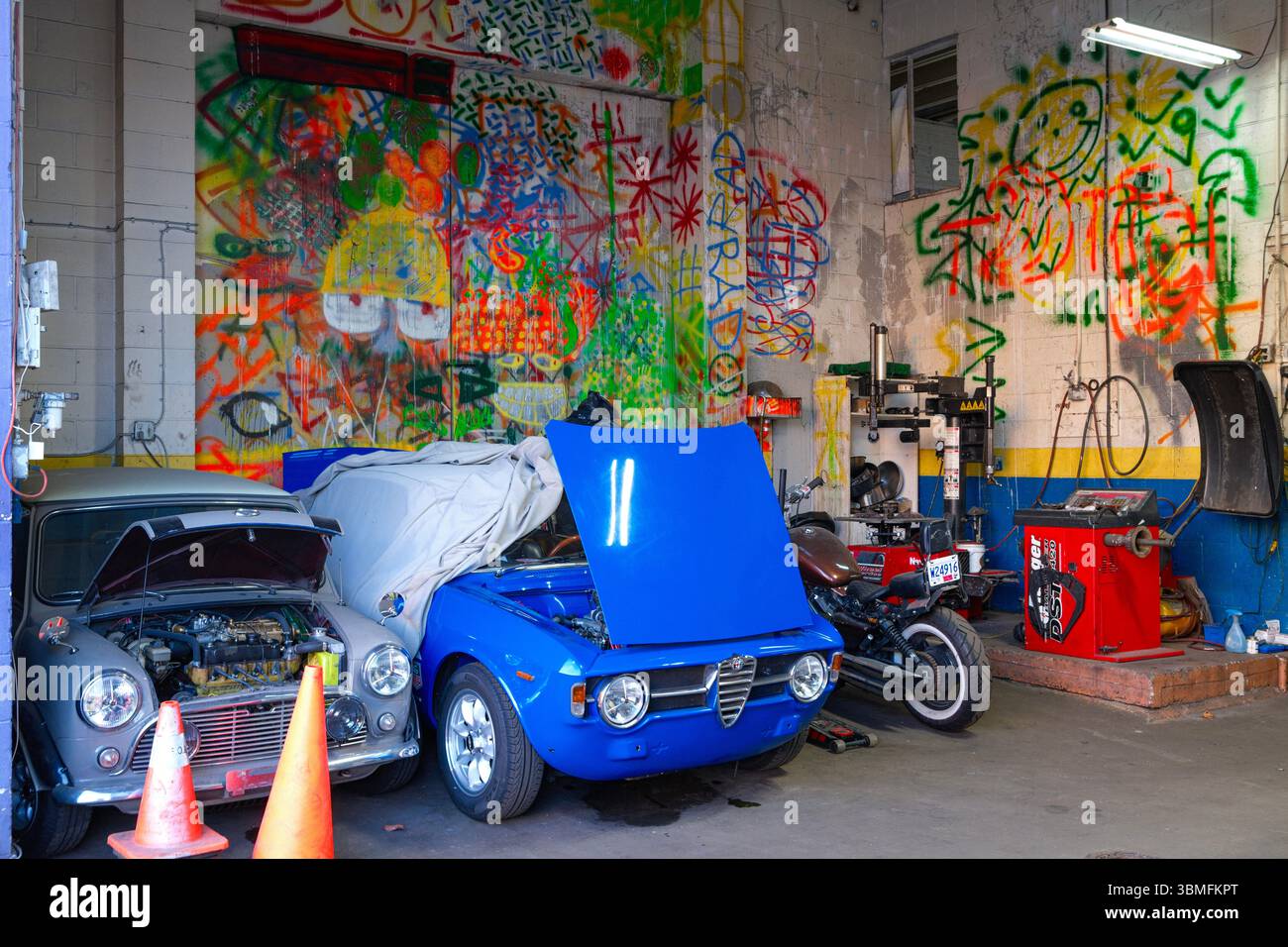 Auto d'epoca e un muro colorato presso il Vancouver Auto Centre a East Vancouver, British Columbia. Foto Stock