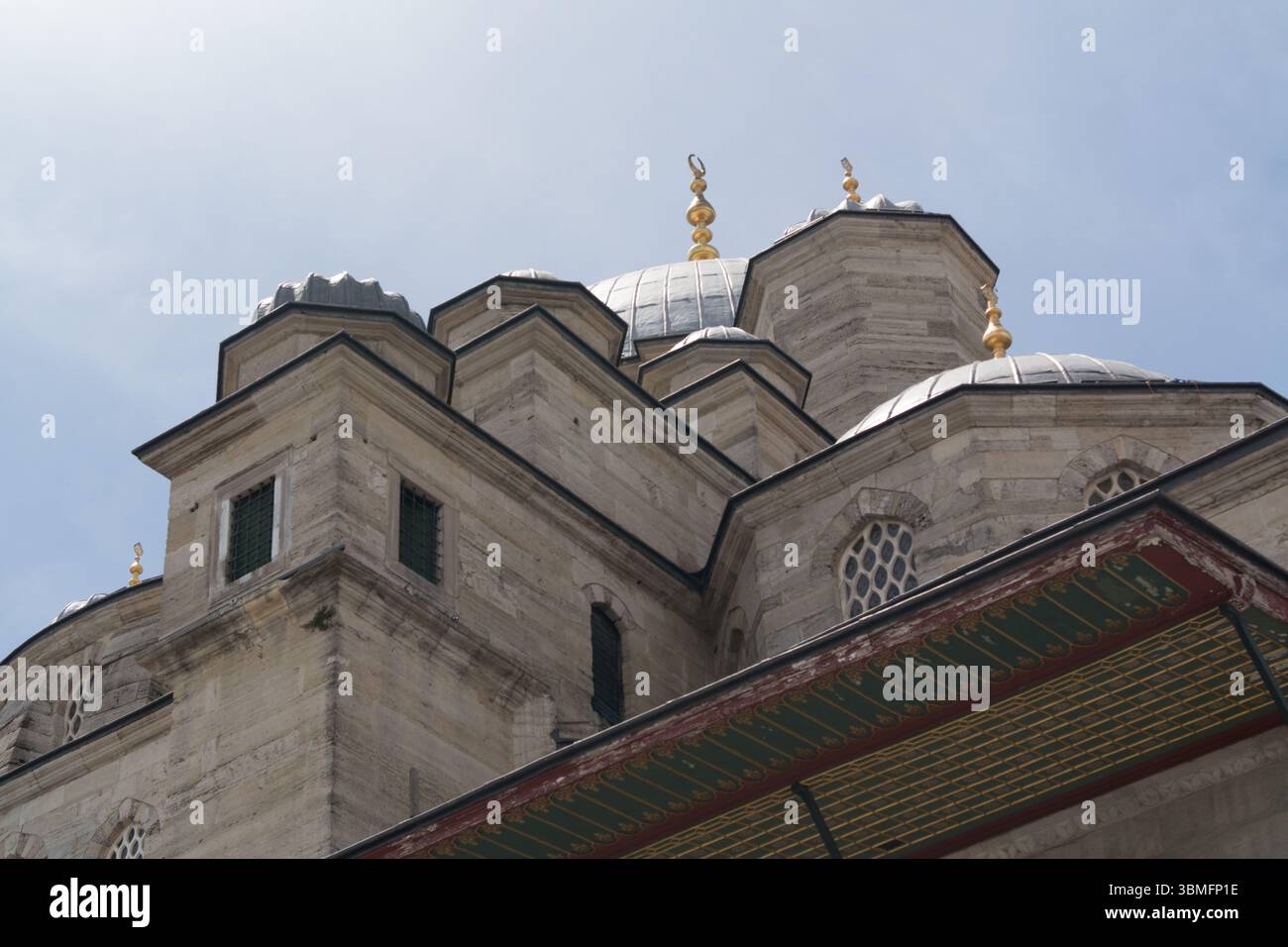 Le cupole e le caratteristiche architettoniche uniche di una moschea di Istanbul mettono in risalto il tradizionale design turco contro un cielo blu. Foto Stock