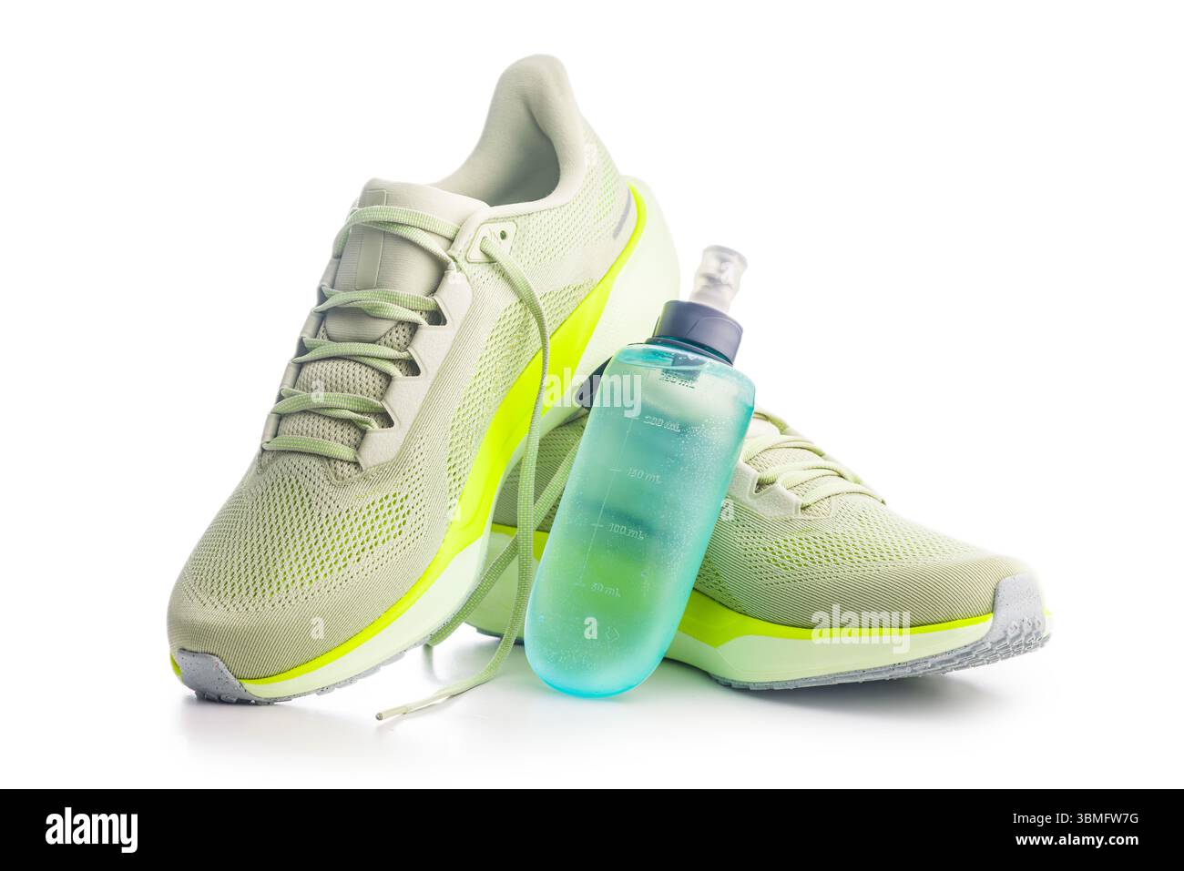 Scarpe da running sportive e bottiglia d'acqua isolata su sfondo bianco. Foto Stock